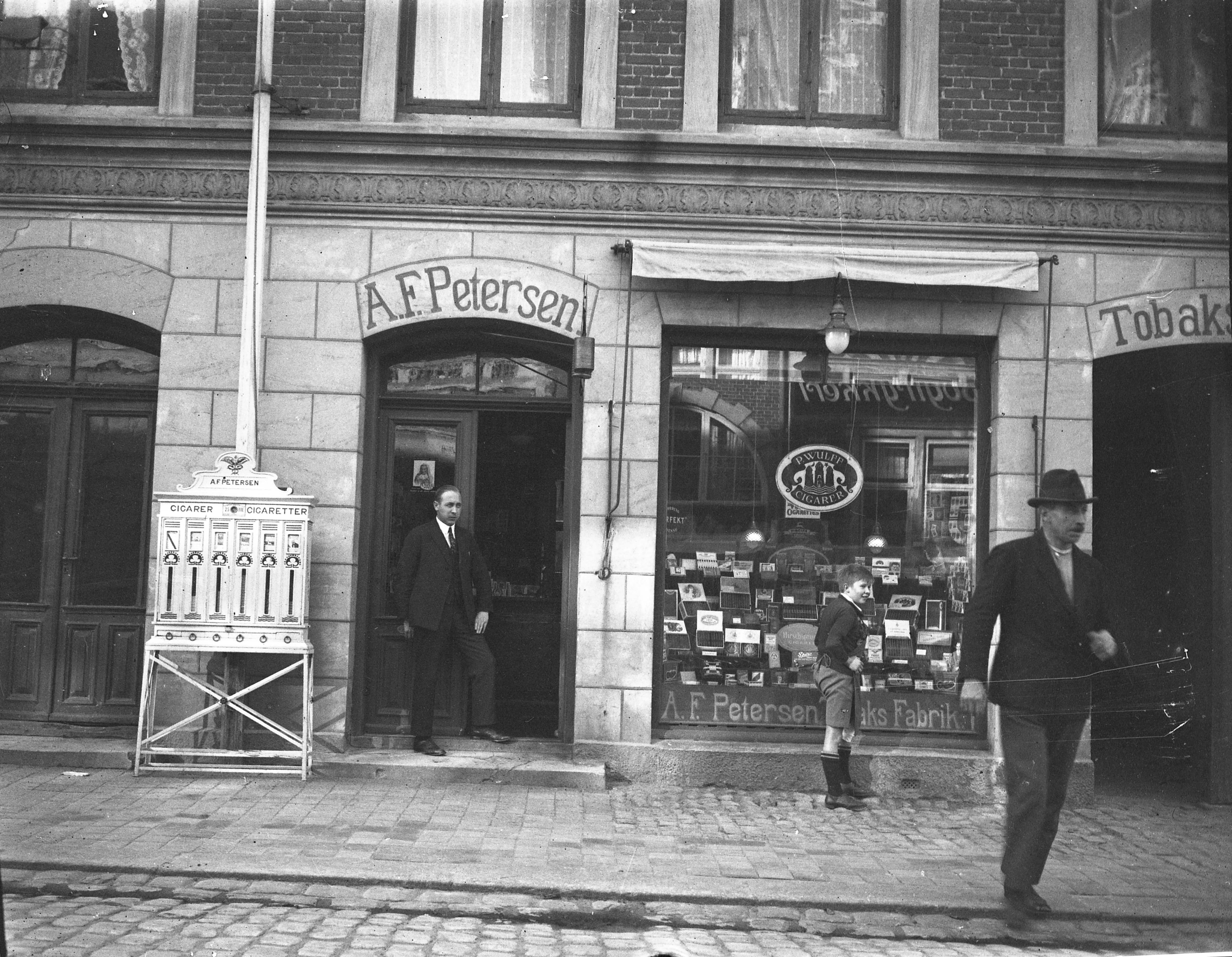 Her er en af de tre fotografier, som er dukket op hos Lokalhistorisk Arkiv på Hillerød Bibliotek, og det skulle angiveligt være tobaksfabrikant A.F. Petersen, der ses i butiksdøren i Slotsgade 51.