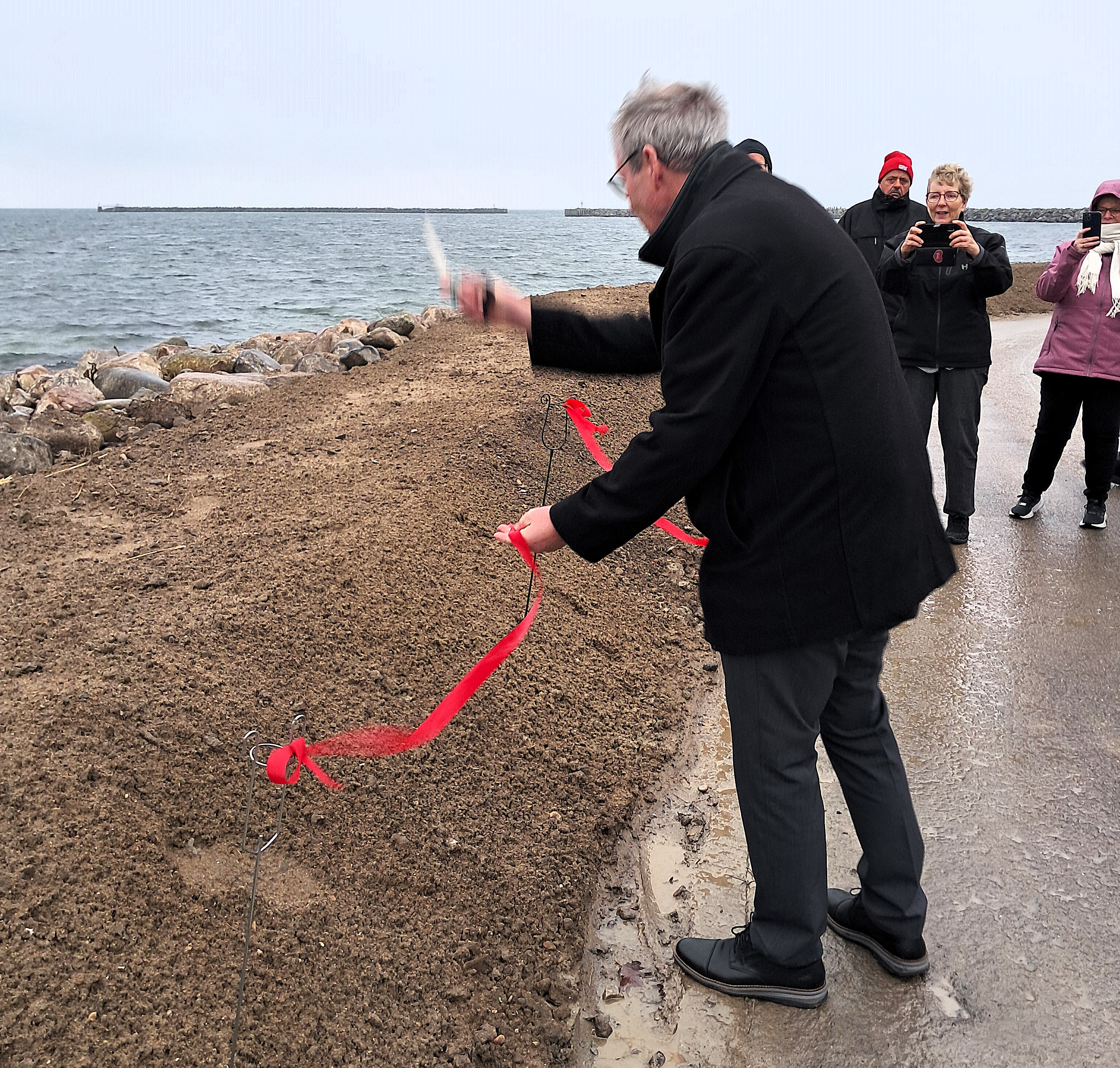 Højvandsdiget ved Strandvej i Korsør er blevet indviet. Her er det borgmester Knud Vincents, som klipper den røde snor.