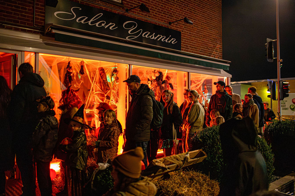 Udendørs lyste bålet op foran halmballer og udklædte personer, der ventede i mørket.