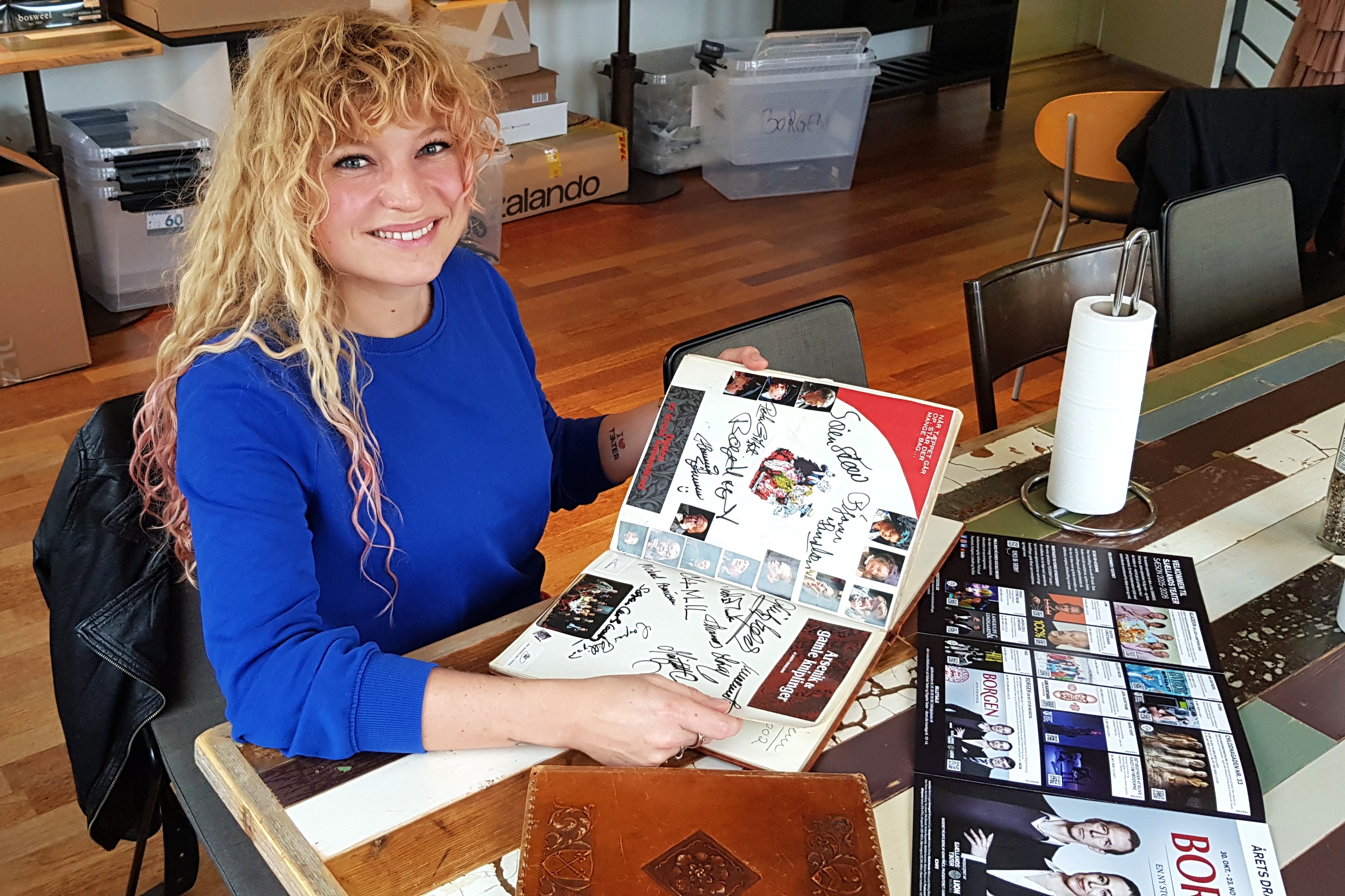 Malou Louise Lindblom bladrer i den jubilerende Holbæk Musik- og Teaterforenings historie i scrapbogen.