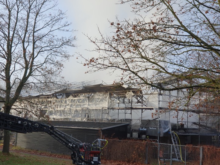 Der er stillads over huset, fordi taget er ved at blive renoveret. Overdækningen er smeltet efter branden.
