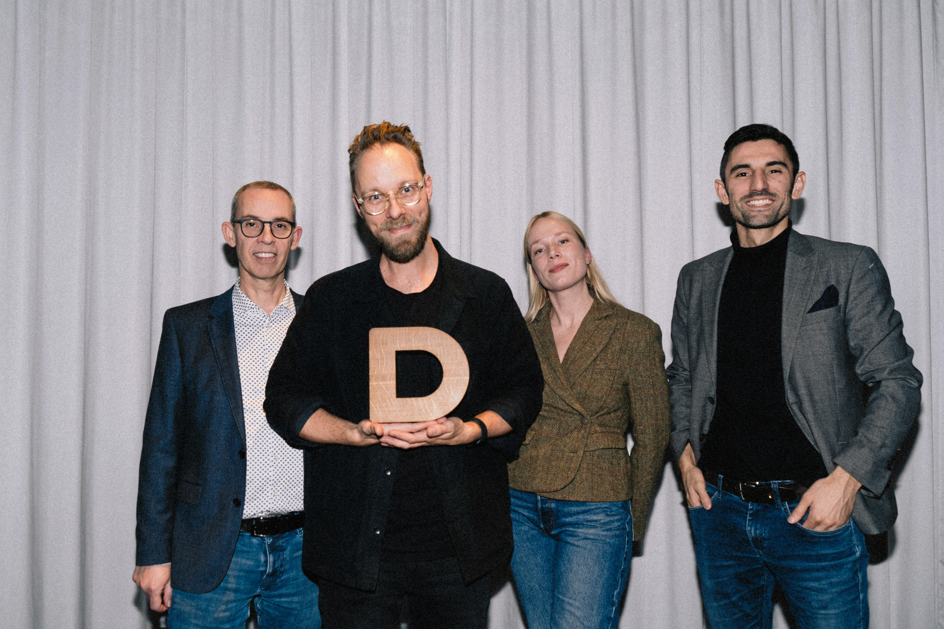- Vi er stolte over, at juryen har belønnet et design, der handler om at skabe værdi gennem ro og enkelhed, siger Martin Virenfeldt, der her viser prisen frem sammen med holdet.