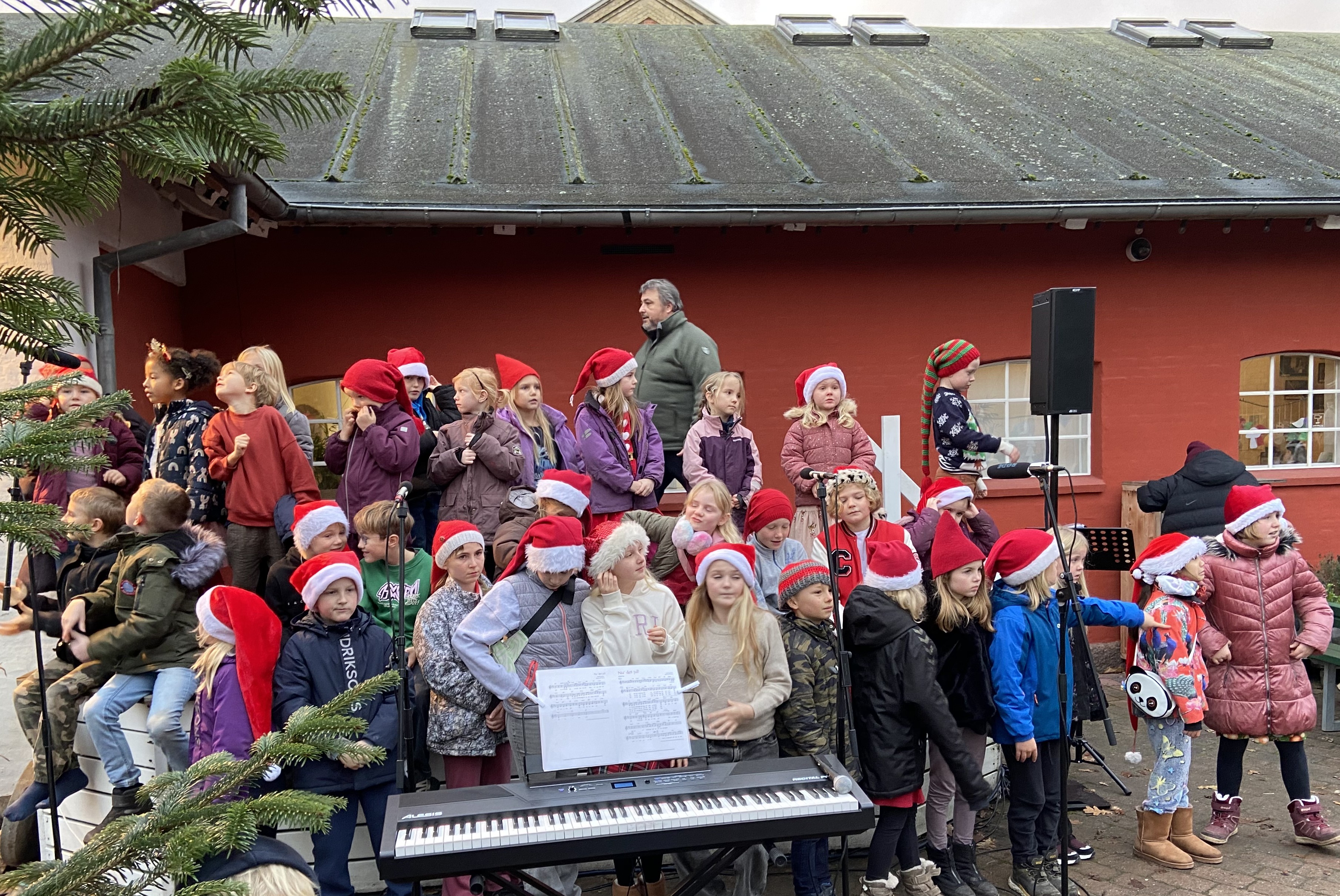 Eleverne fra Slotsparkens Friskole sang julen ind på Rejsestaldens udendørsscene.