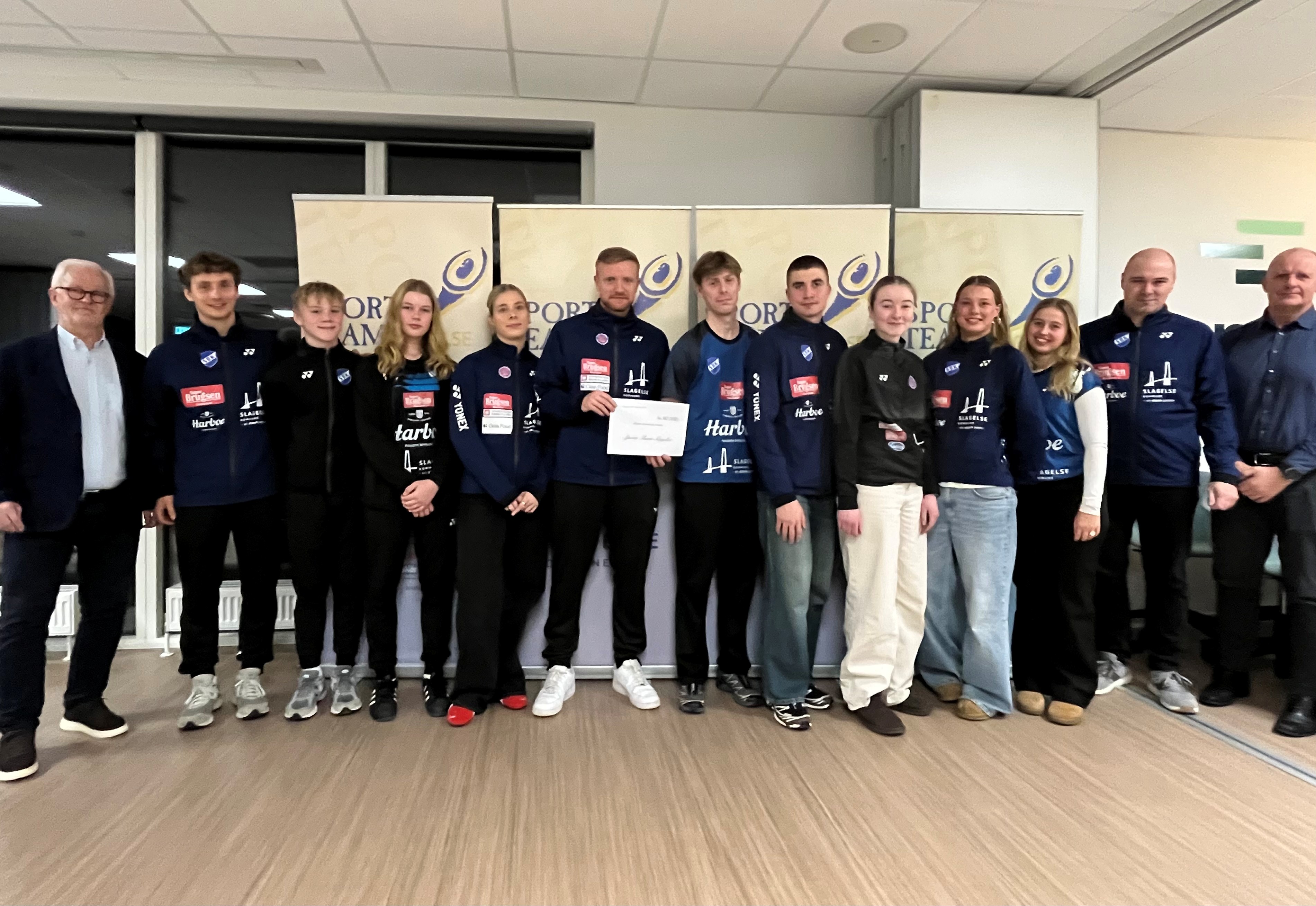 Badmintonklubben fik sidste år 90.000 kroner fra Sports Team Slagelse til eliteudviklingsarbejdet. Yderst til højre formand Michael Stage og i midten med checken den nye cheftræner Søren Toft Hansen.