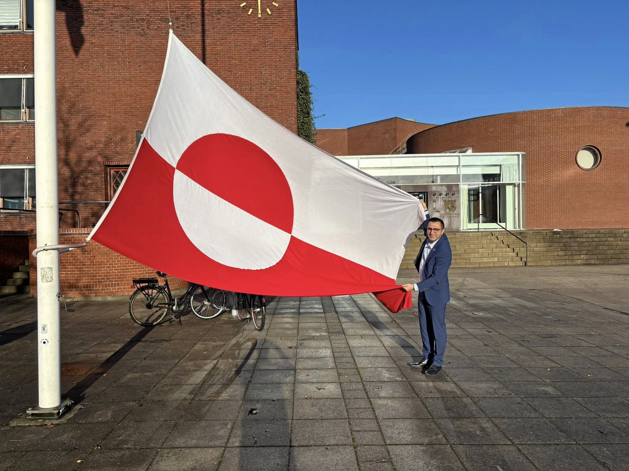 Serdal Benli med det grønlandske flag før det blev hejst i Gladsaxe.