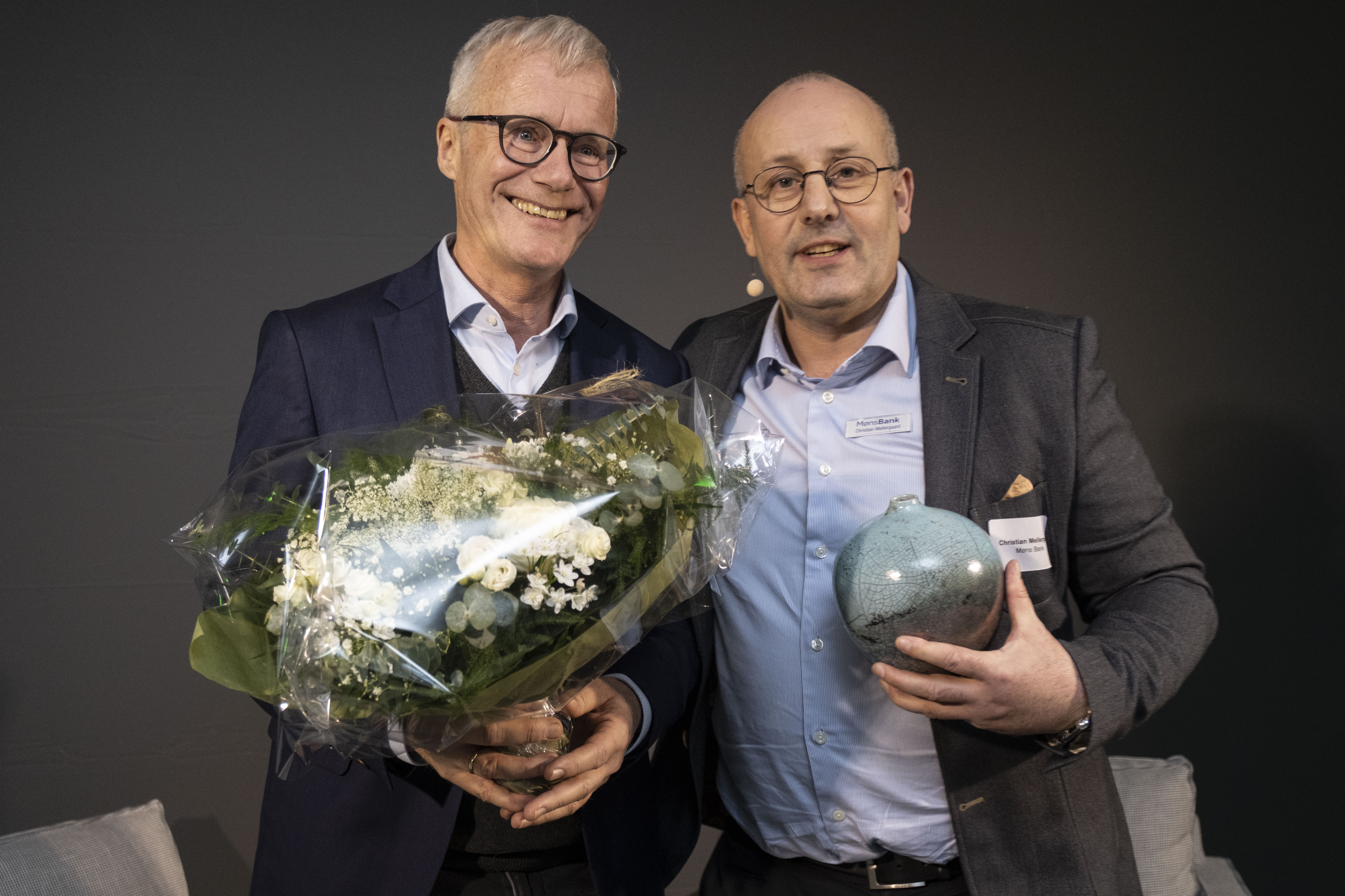 Direktør i Geocenter Møns Klint Nils Natorp (tv.) blev overrasket med Overraskelsensprisen 2025 af Christian Mellergaard fra Møns Bank. Malt i Ørslev