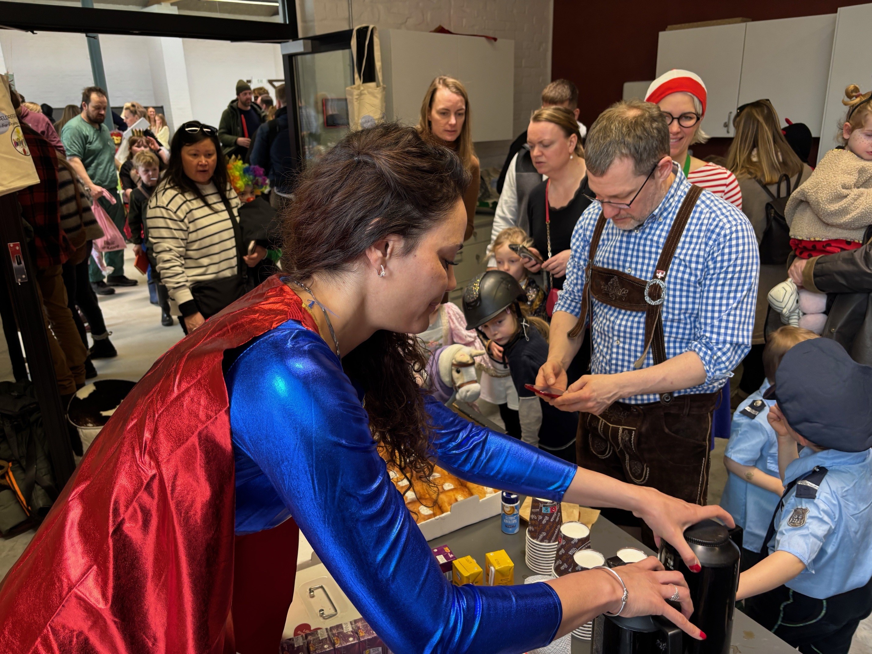 Super Woman alias Jasmine Søgaard fra forældreforeningen passer caféen under lørdagens fastelavn i Støberihallerne.