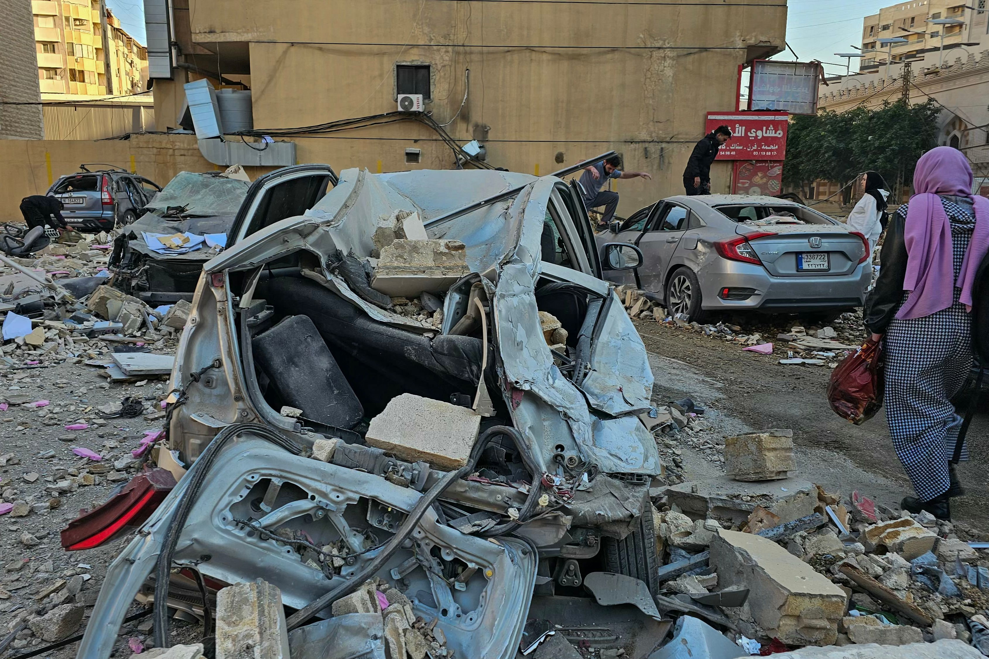 Folk undersøger vraget af biler, der blev beskadiget i et israelsk luftangreb i den sydlige Beirut-forstad Haret Hreik. (Arkivfoto).