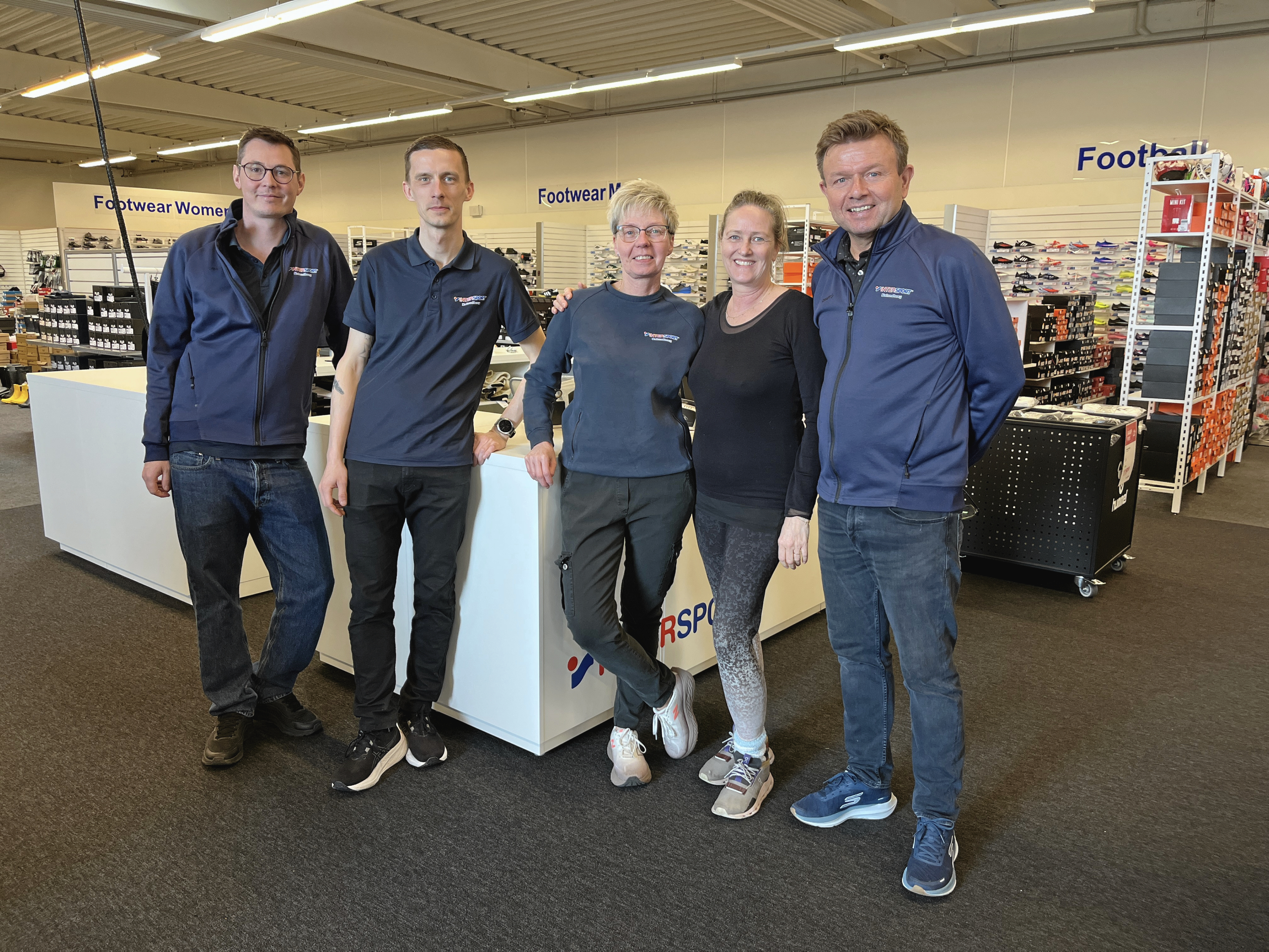 Steen Møller (yderst til højre), indehaver af Intersport Kalundborg, flankeret af sit team foran sportsbutikkens nye kasseområde.