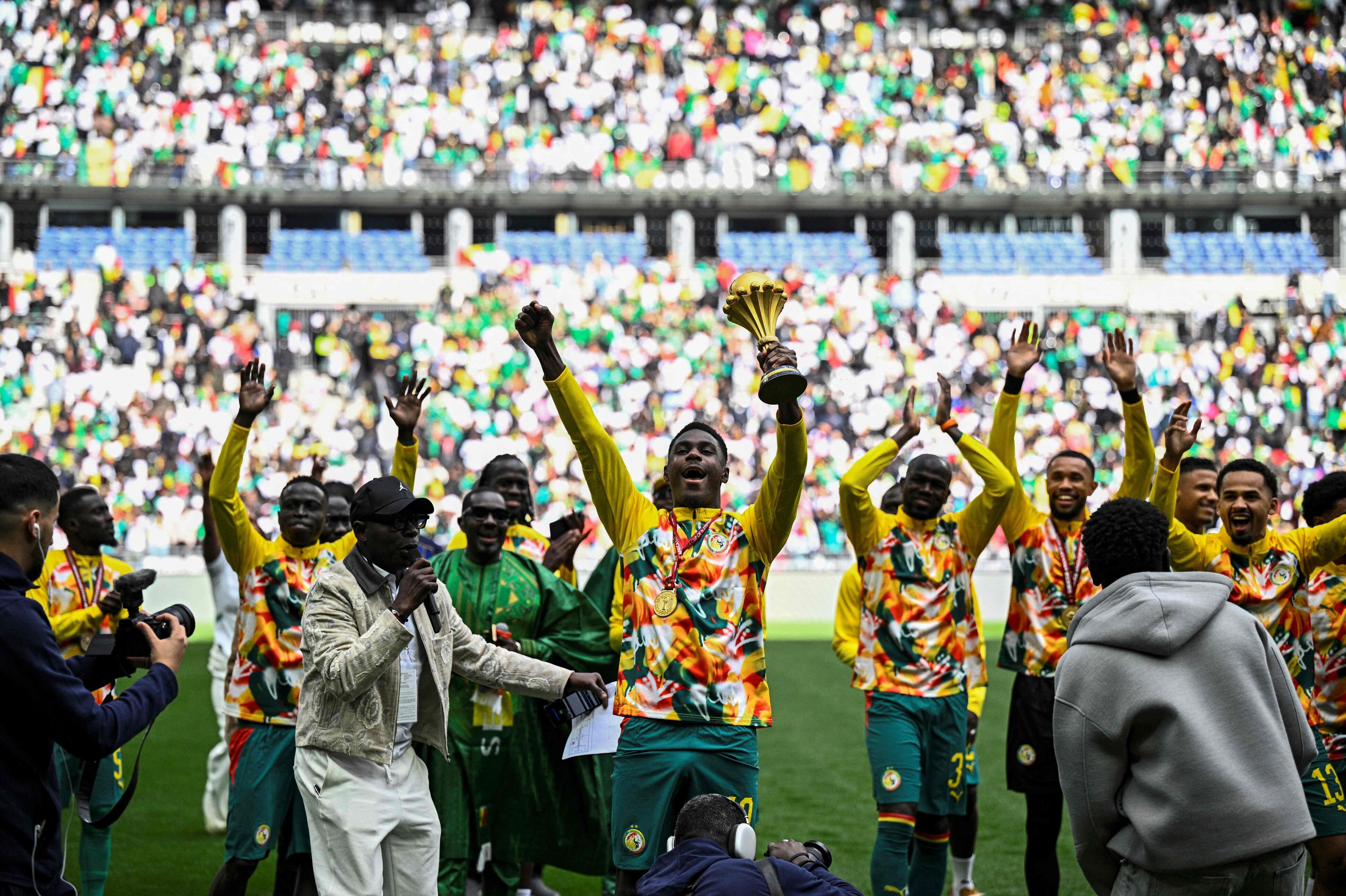 Senegals spillere jubler med AFCON-trofæet, selv om det er blevet frataget, før en venskabskamp mod Peru på Stade de France i Paris.