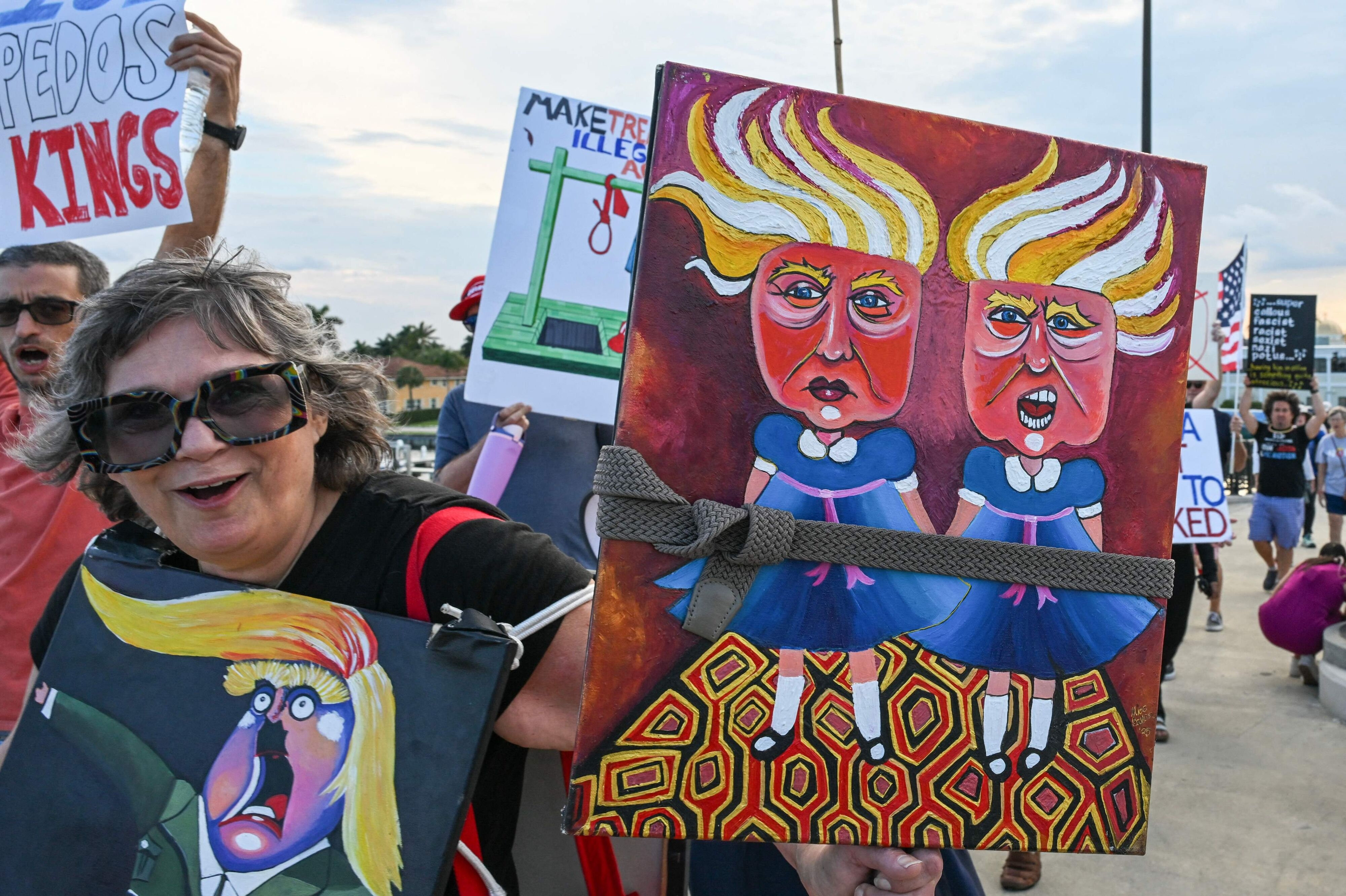 Demonstranter ses lørdag med skilte nær Trumps ejendom Mar-a-Lago i den amerikanske delstat Florida.