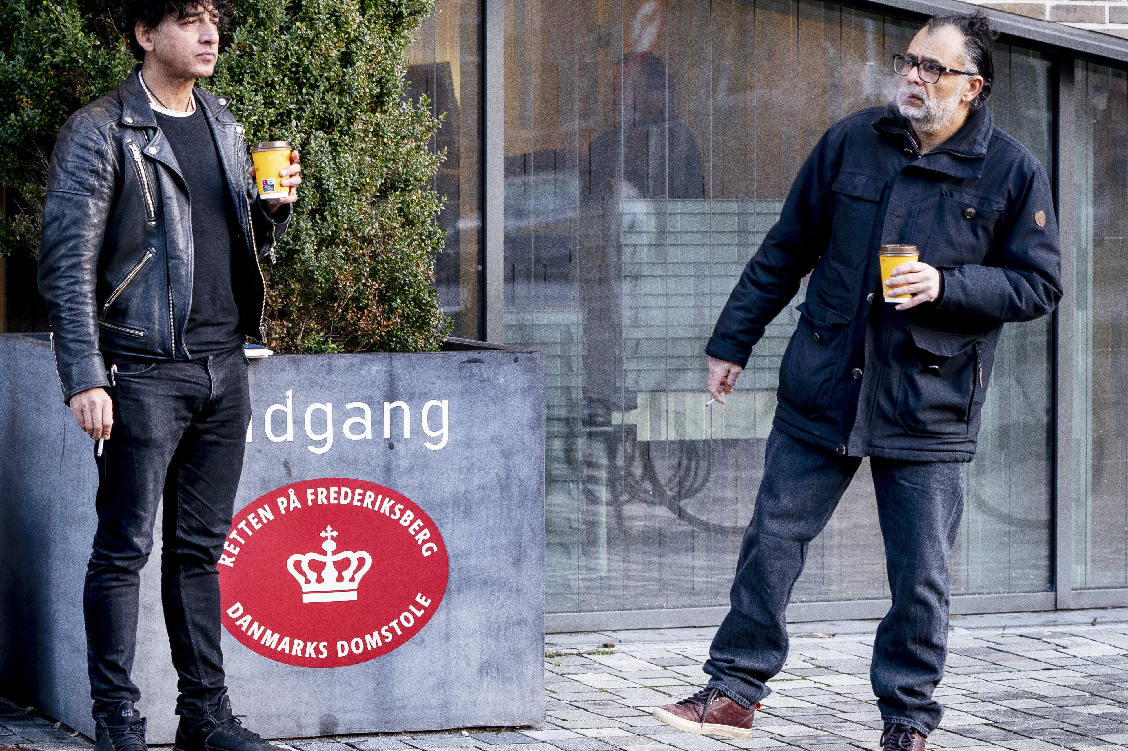 Instruktør Manyar Parwani (t.v.) og producent Omar Marzouk (t.h.) har fredag fået rettens ord for, at de ikke må bruge optagelser af forfatter Sara Omar i en dokumentarfilm. De to mænd ses her i en pause foran retten ved et retsmøde i februar 2022, hvor en dommer første gang tog stilling til et midlertidigt forbud. (Arkivfoto).