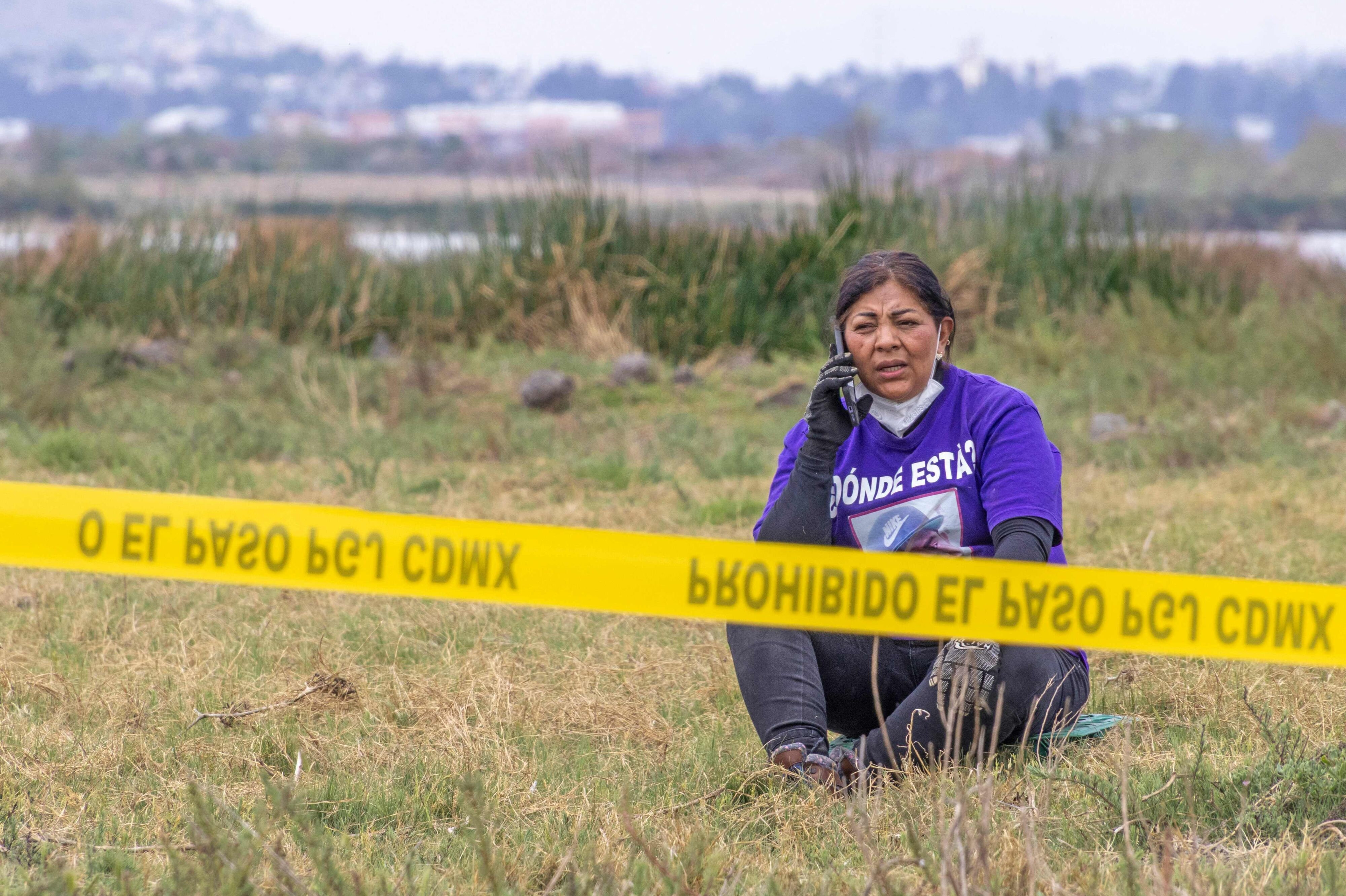Kvinde ses i T-shirt med teksten "Hvor er han?" nær søen Chalco den 15. april. Her har man ledt efter jordiske rester af forsvundne personer. (Arkivfoto).
