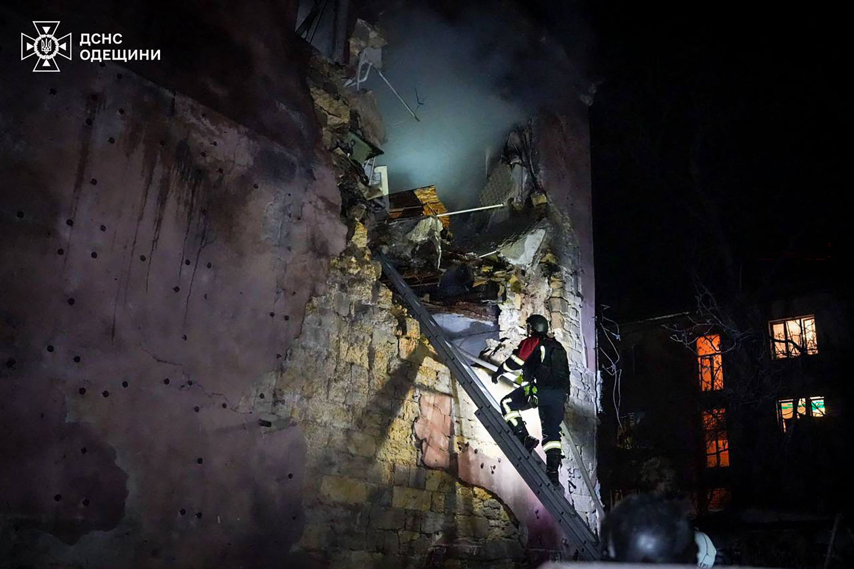 Et billede, som Ukraines statslige redningstjeneste har udgivet, viser en ansat kravle op ad en stige for at finde overlevende efter et russisk angreb i Odesa.