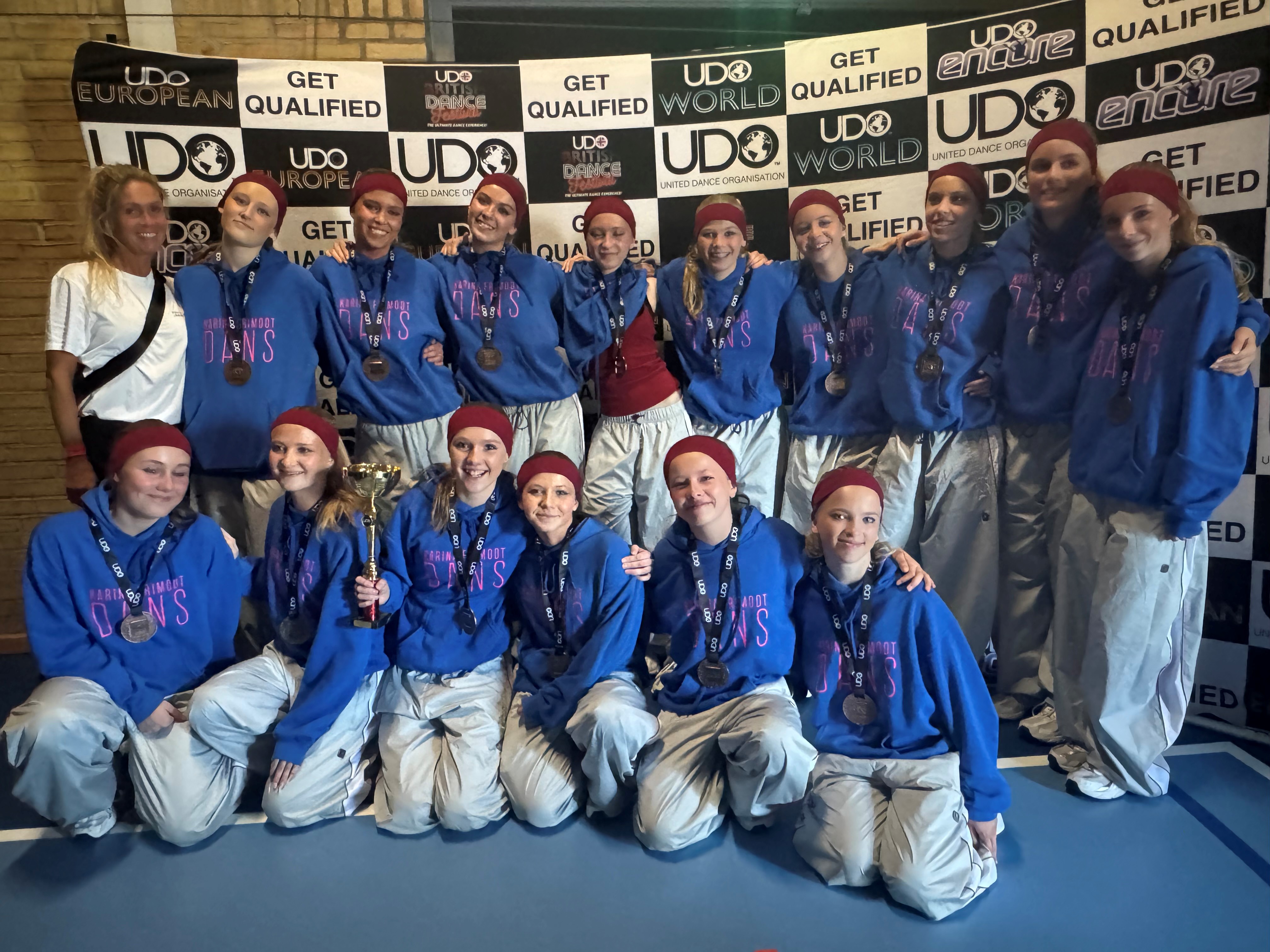 Så glade var de 15 dansere og deres træner, da bronzemedaljerne var en realitet.