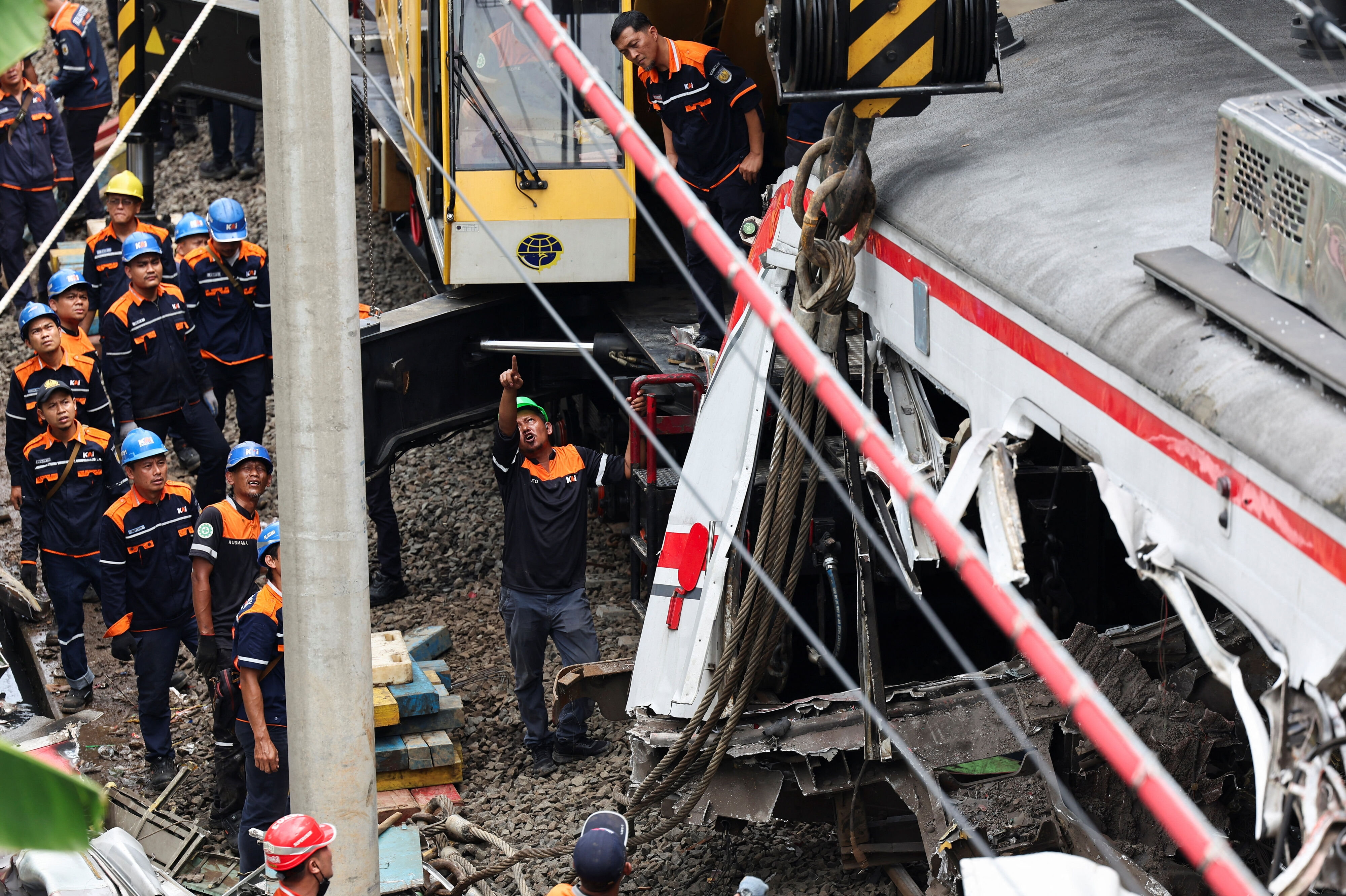 Teknikere ses tirsdag arbejde på ulykkesstedet efter et dødeligt sammenstød mellem to tog i Bekasi, der ligger i udkanten af Jakarta.