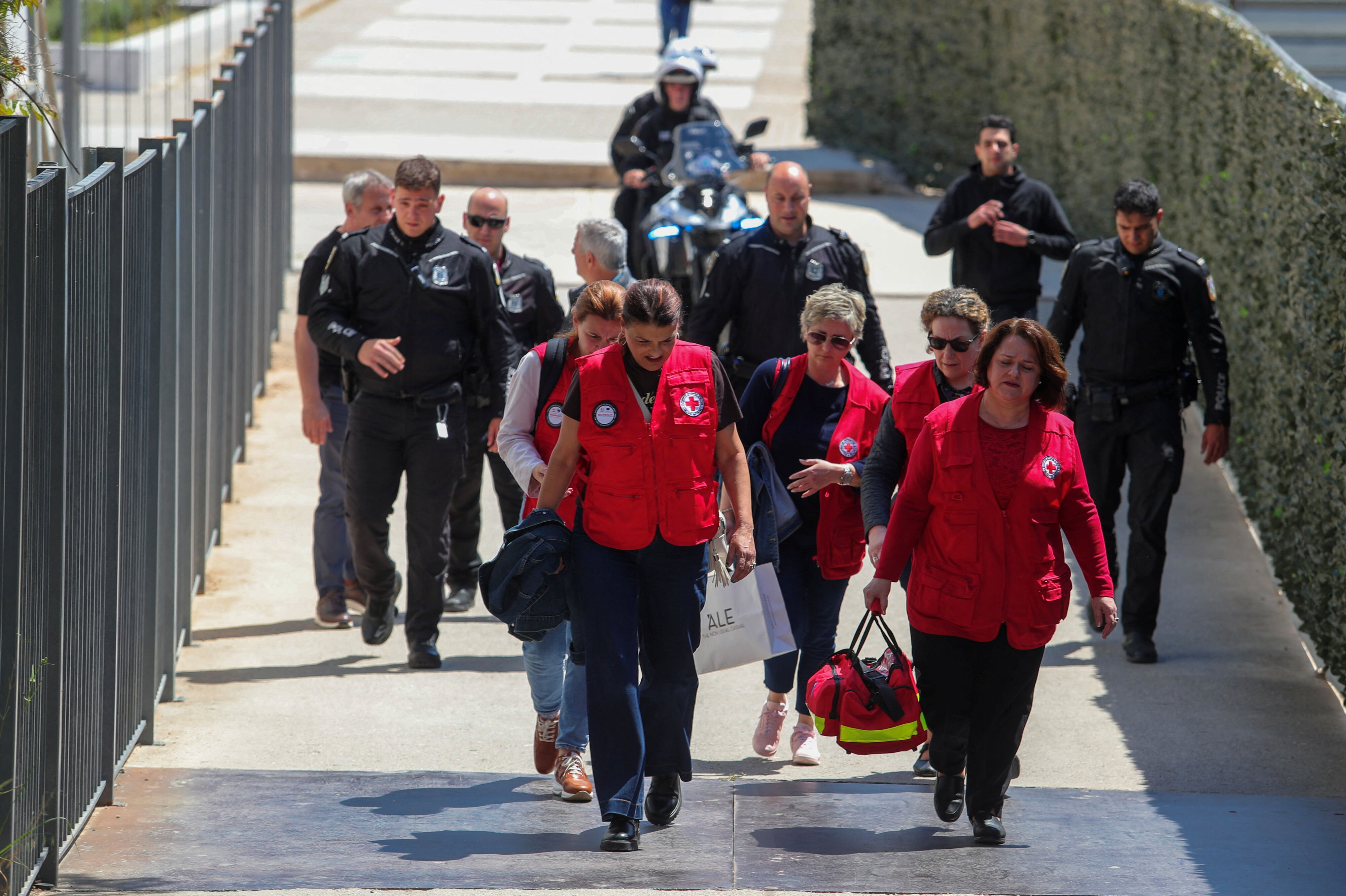 Redningsfolk og politibetjente går uden for en retsbygning i Athen, hvor et skyderi har fundet sted tirsdag.