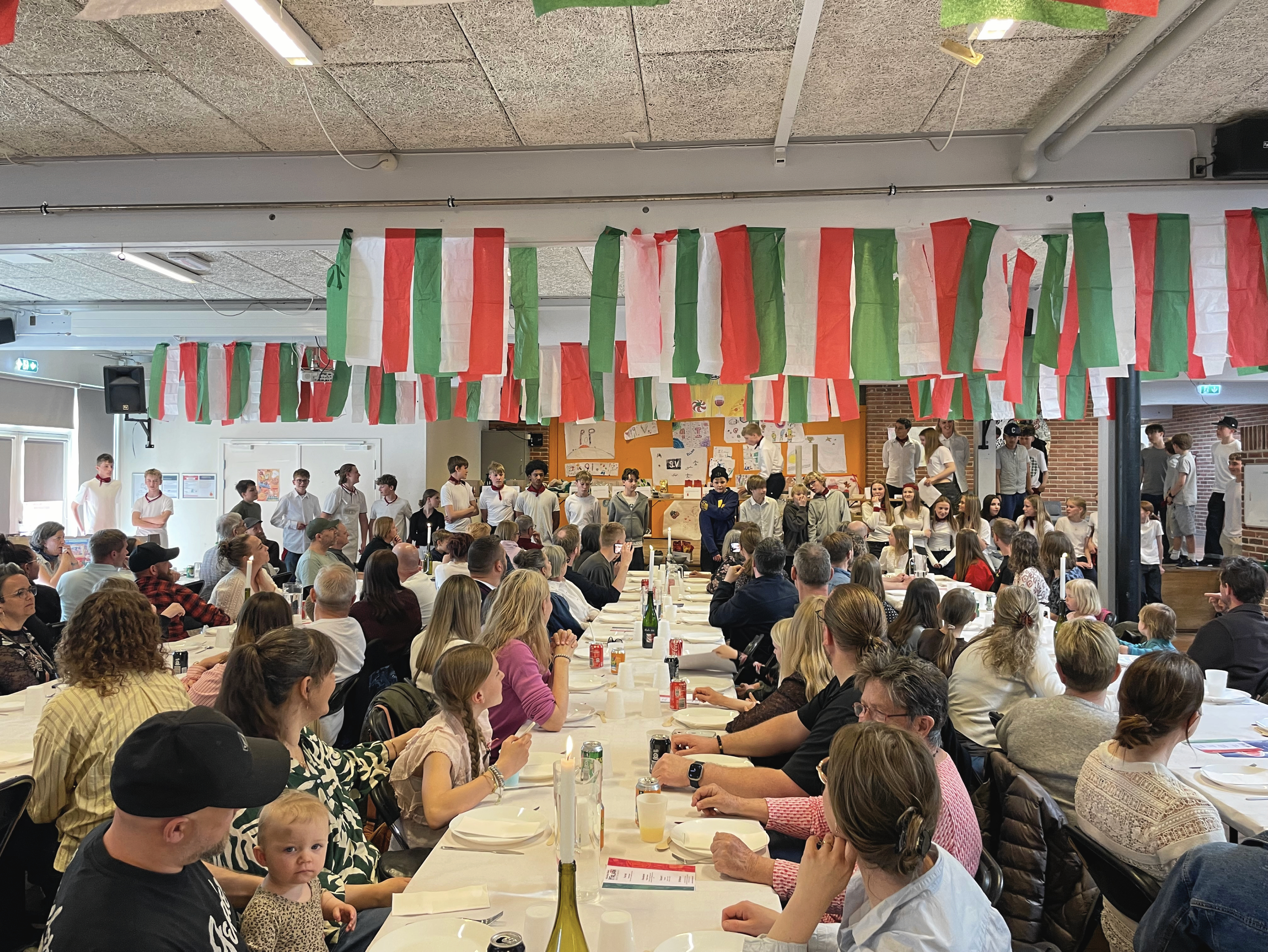 124 gæster havde på forhånd købt billetter. De blev mødt af hjemmelavede italienske flag, store pastaskruer over boderne og fire langborde pyntet med elevernes egne lysestager.