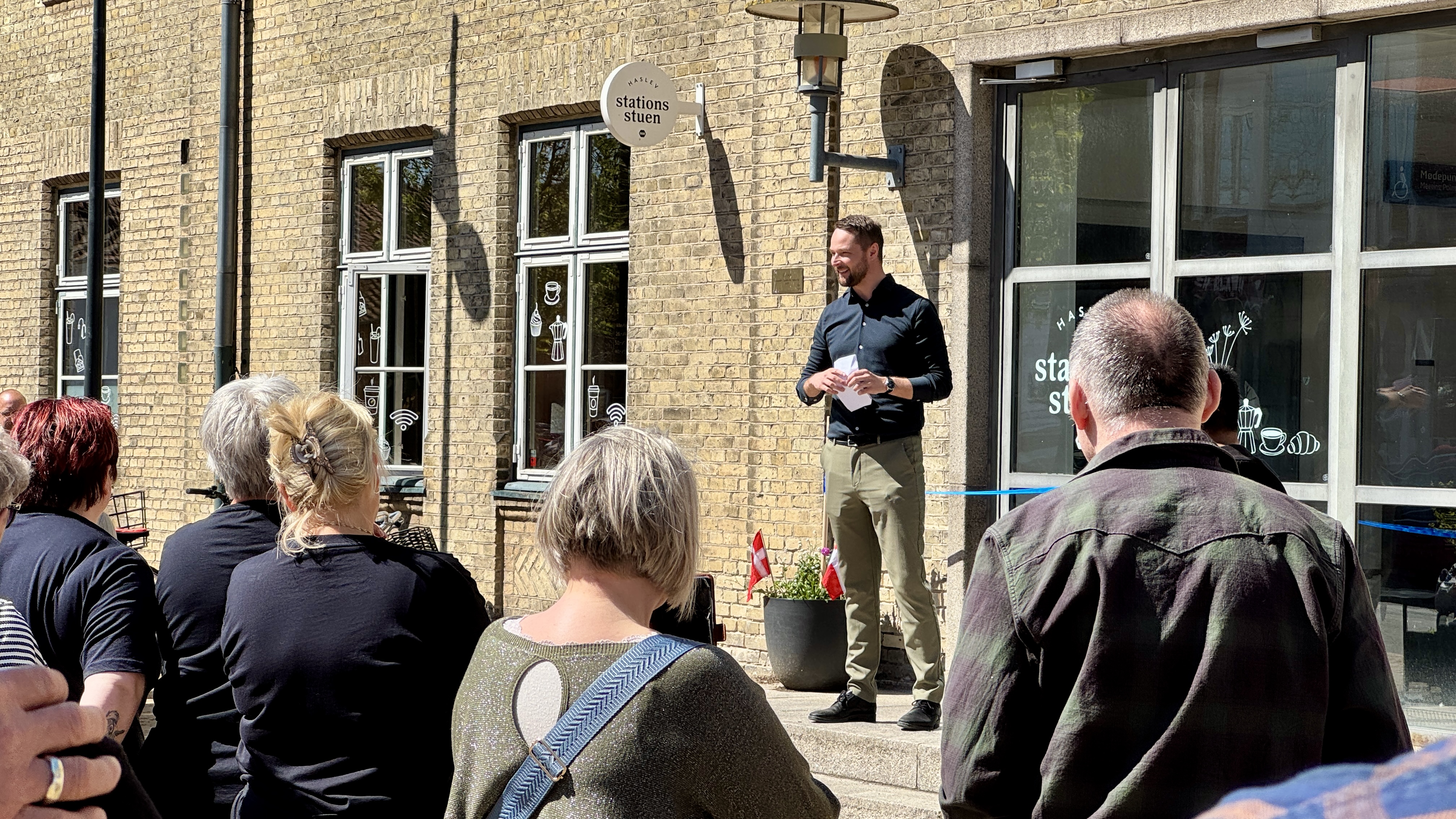 Borgmester Mikkel Dam (LA) holdt tale foran Stationsstuen ved genåbningen, hvor op mod 60 fremmødte lyttede med.
