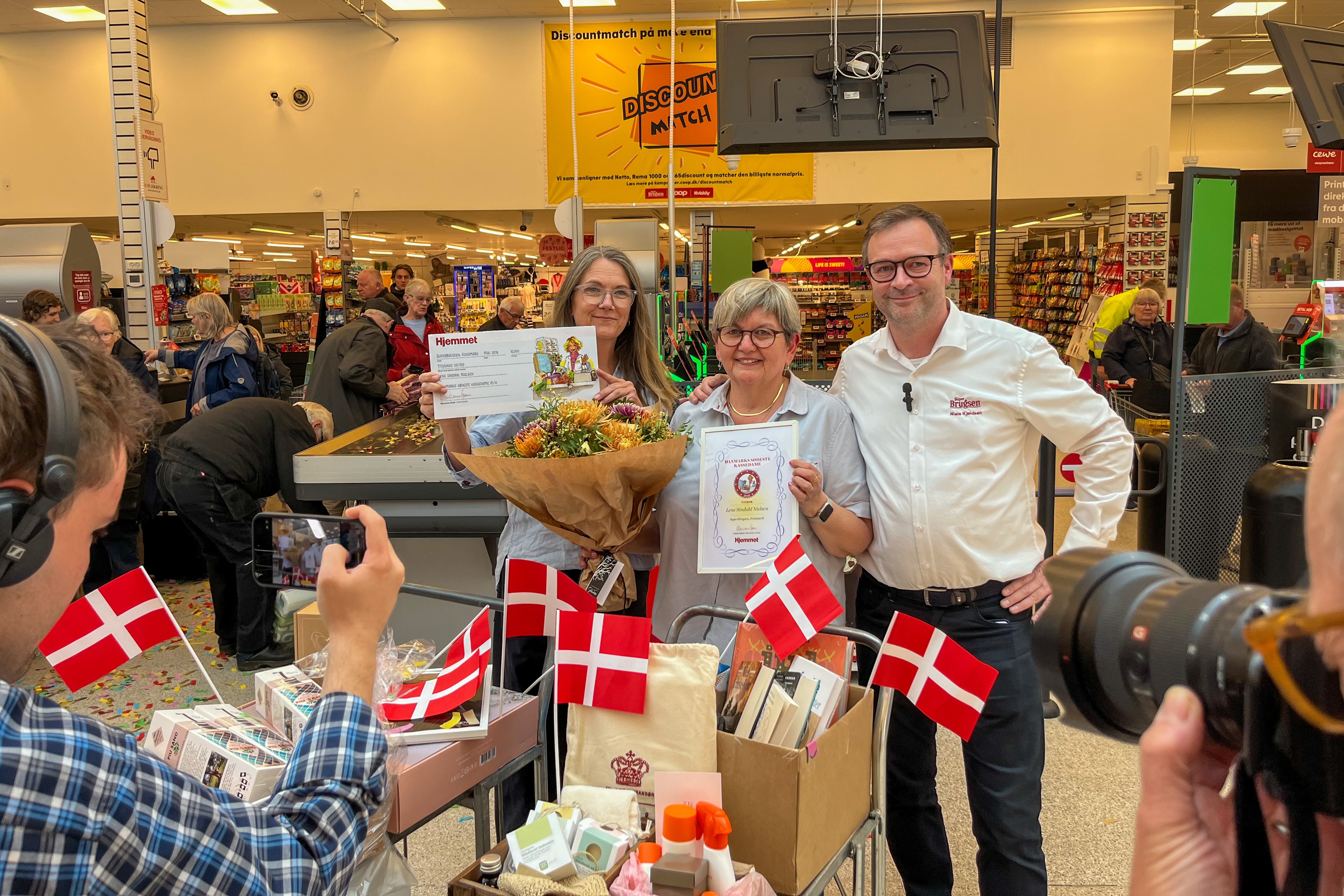 Lene Sindahl Nielsen i midten sammen med journalist Anette Løkken fra Hjemmet og varehuschef Niels Kjeldsen umiddelbart efter overraskelsen.