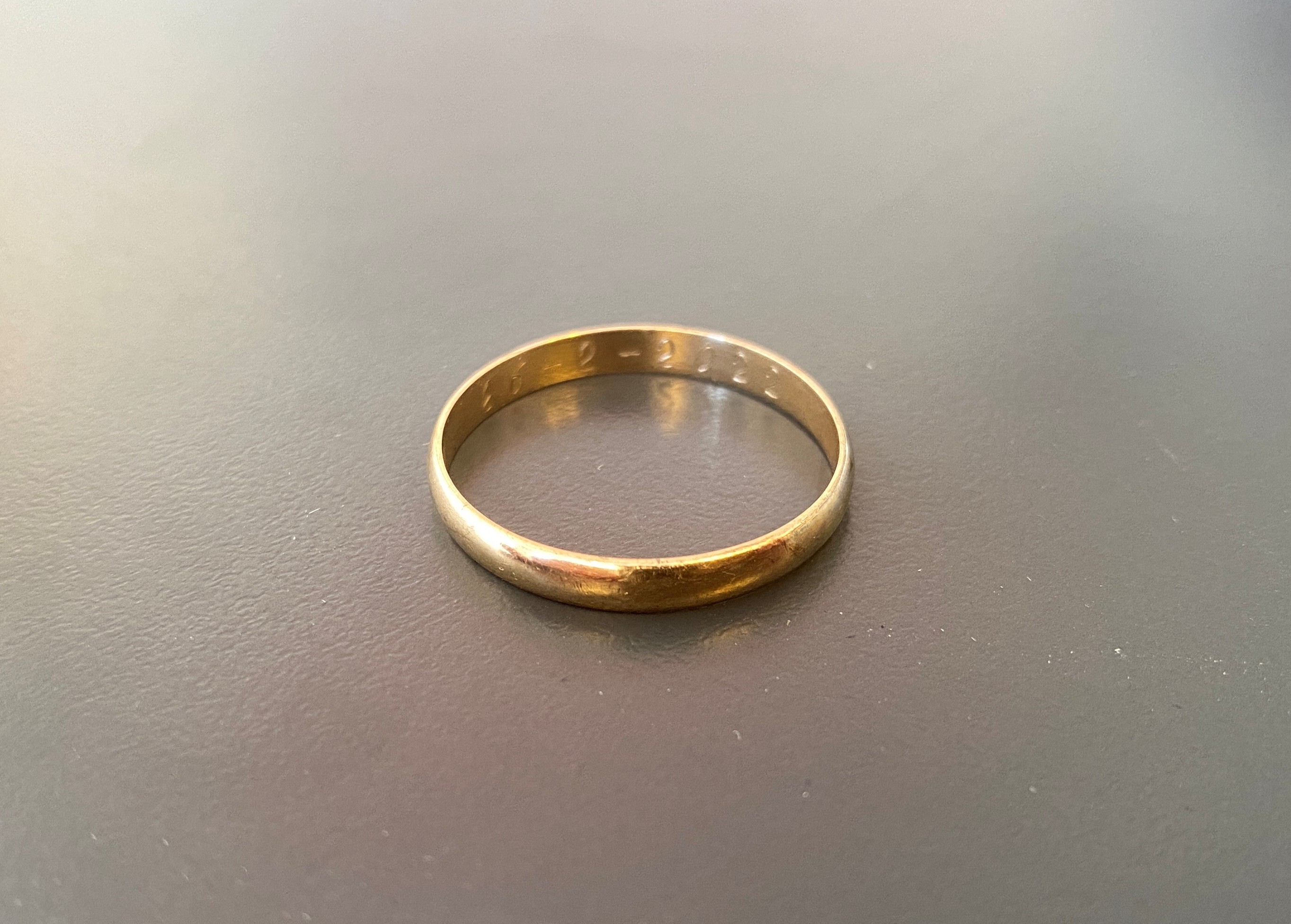 Hvem er ejeren af denne vielsesring med datoen 26. februar 2022 indgraveret?