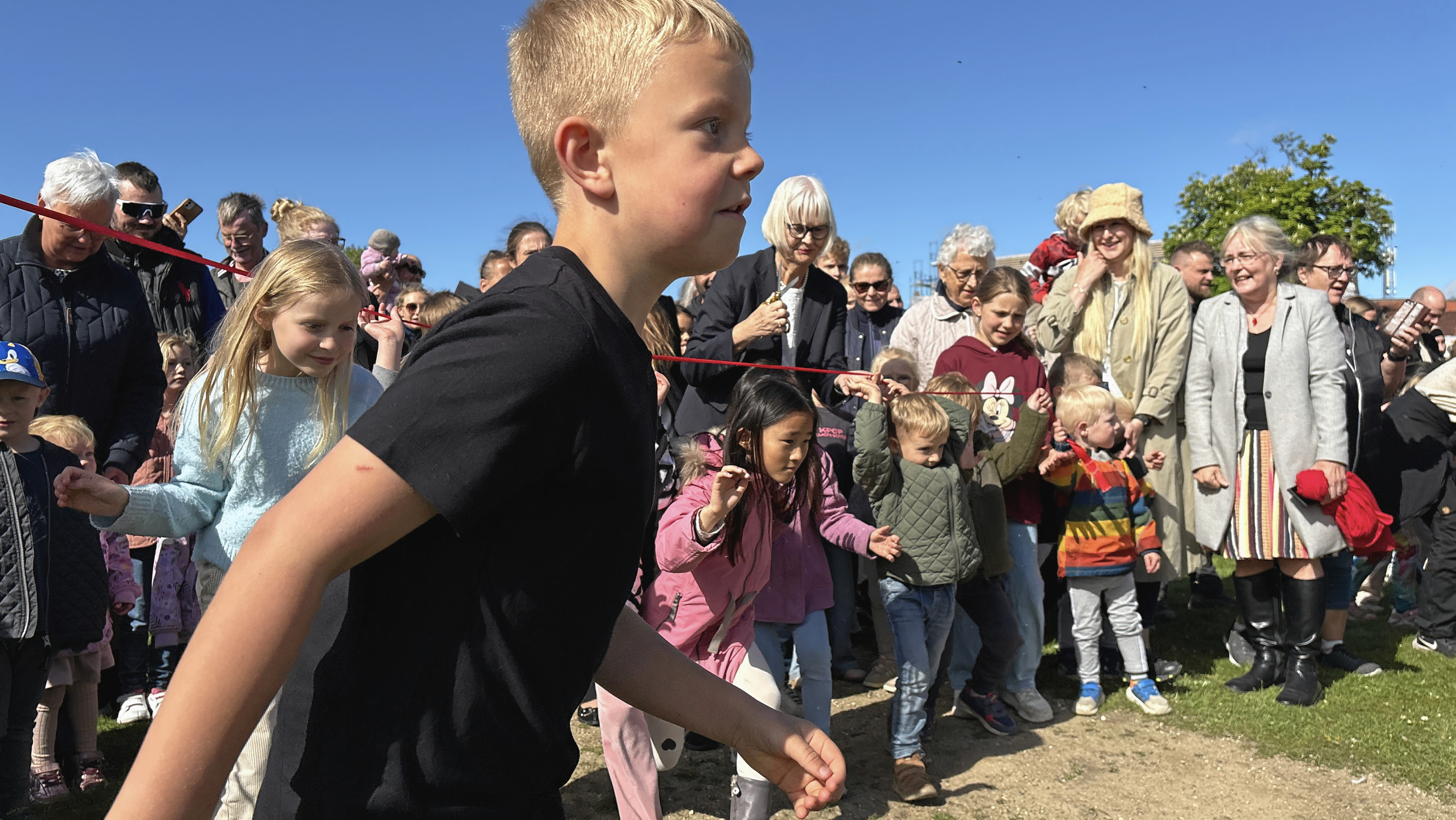 Annette Kobberup Stougaard fra CO-RO Fonden havde ikke nået at klippe det røde bånd, før børnene var smuttet under, fordi de naturligvis ikke kunne vente længere.