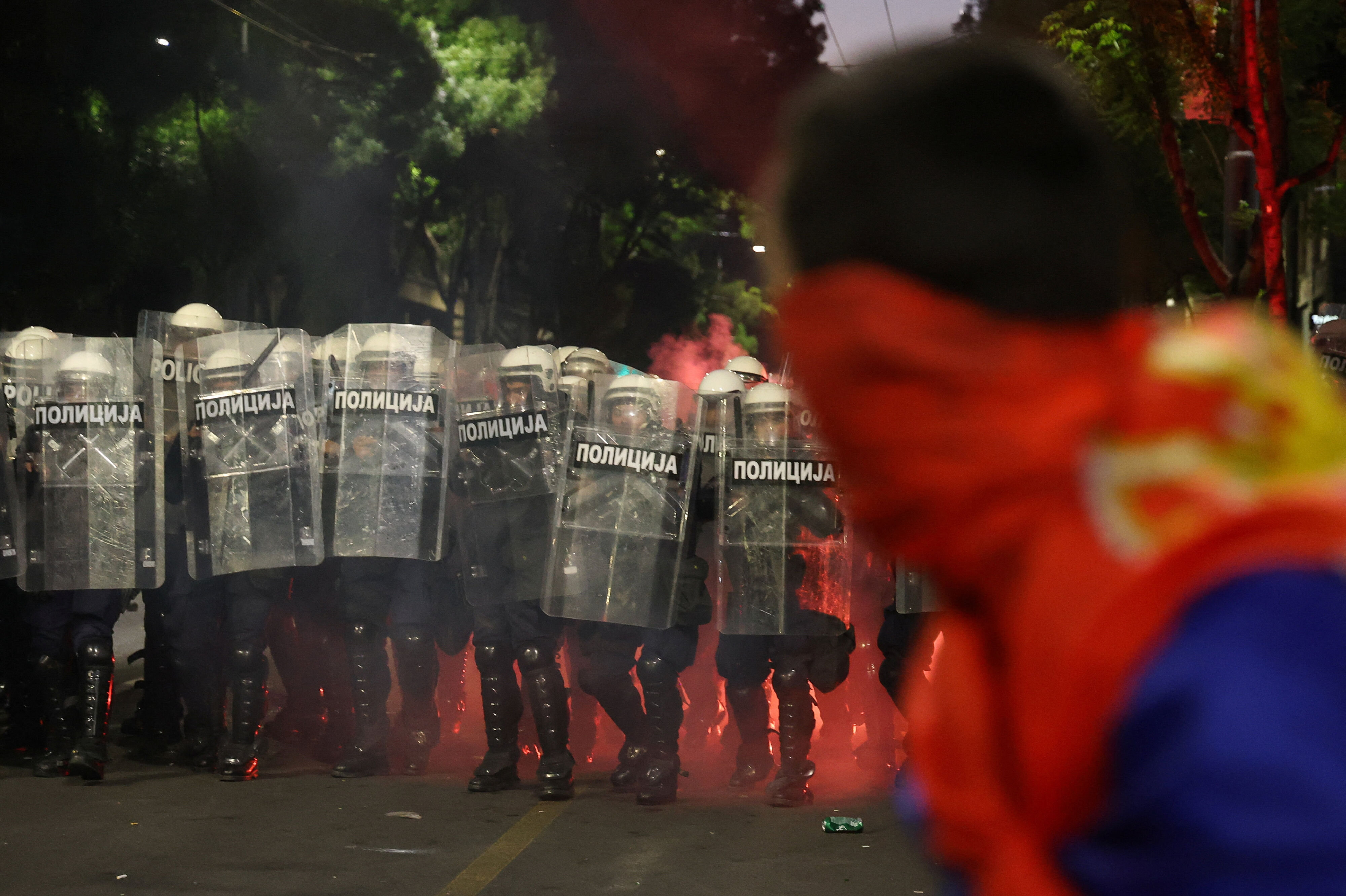 Et nødblus brænder blandt en gruppe kampklædte betjente, der lørdag aften er sat ind i forbindelse med en regeringskritisk demonstration i Serbiens hovedstad, Beograd. Demonstranterne kræver nyvalg som følge af en halvandet år gammel skandale om et kollapset tag, der dræbte 16 mennesker på togstationen i byen Novi Sad i 2024.