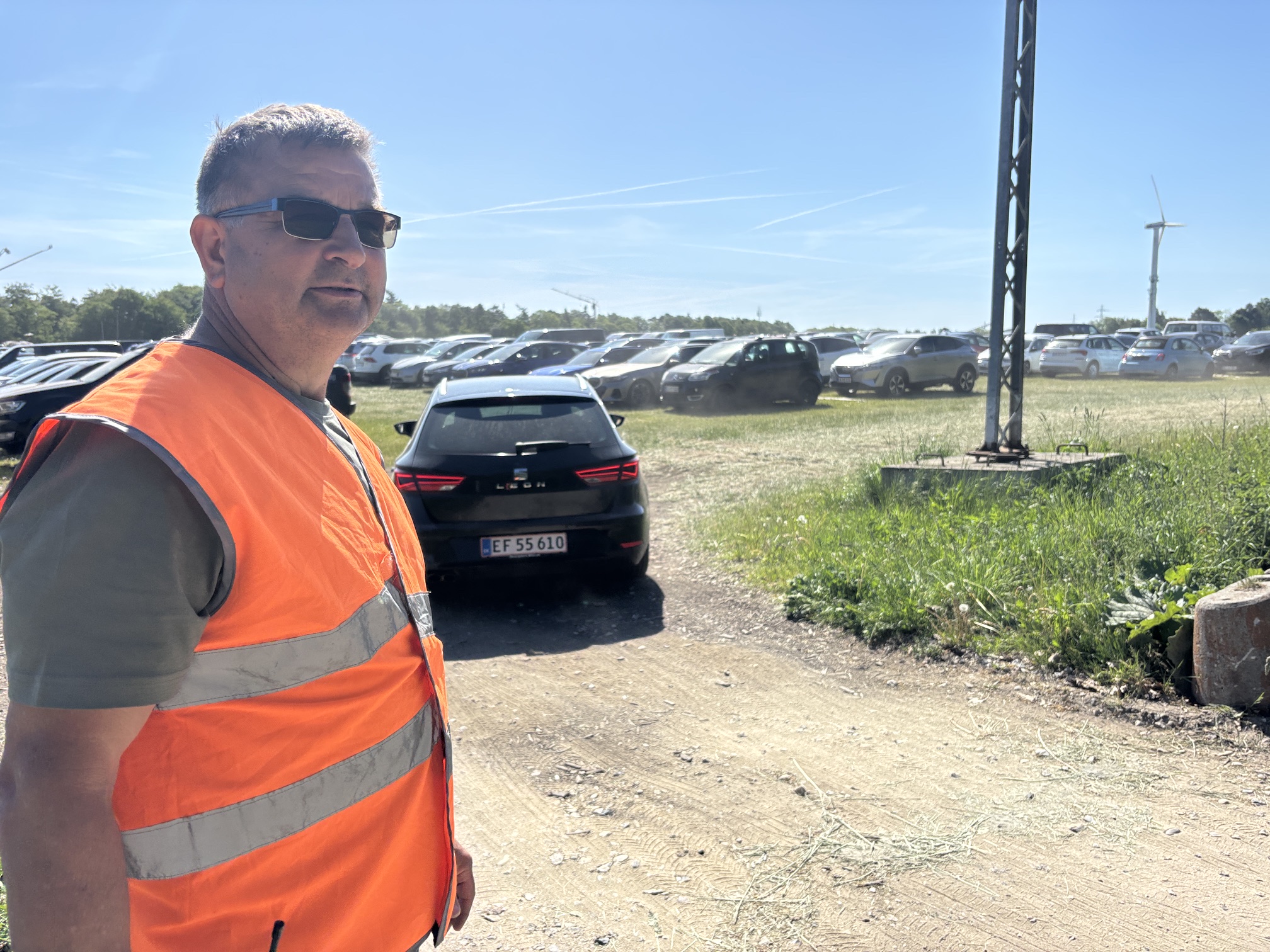 Mads Christensen nyder sol og snak som frivillig på parkeringspladsen ved Roskilde Dyrskue.
