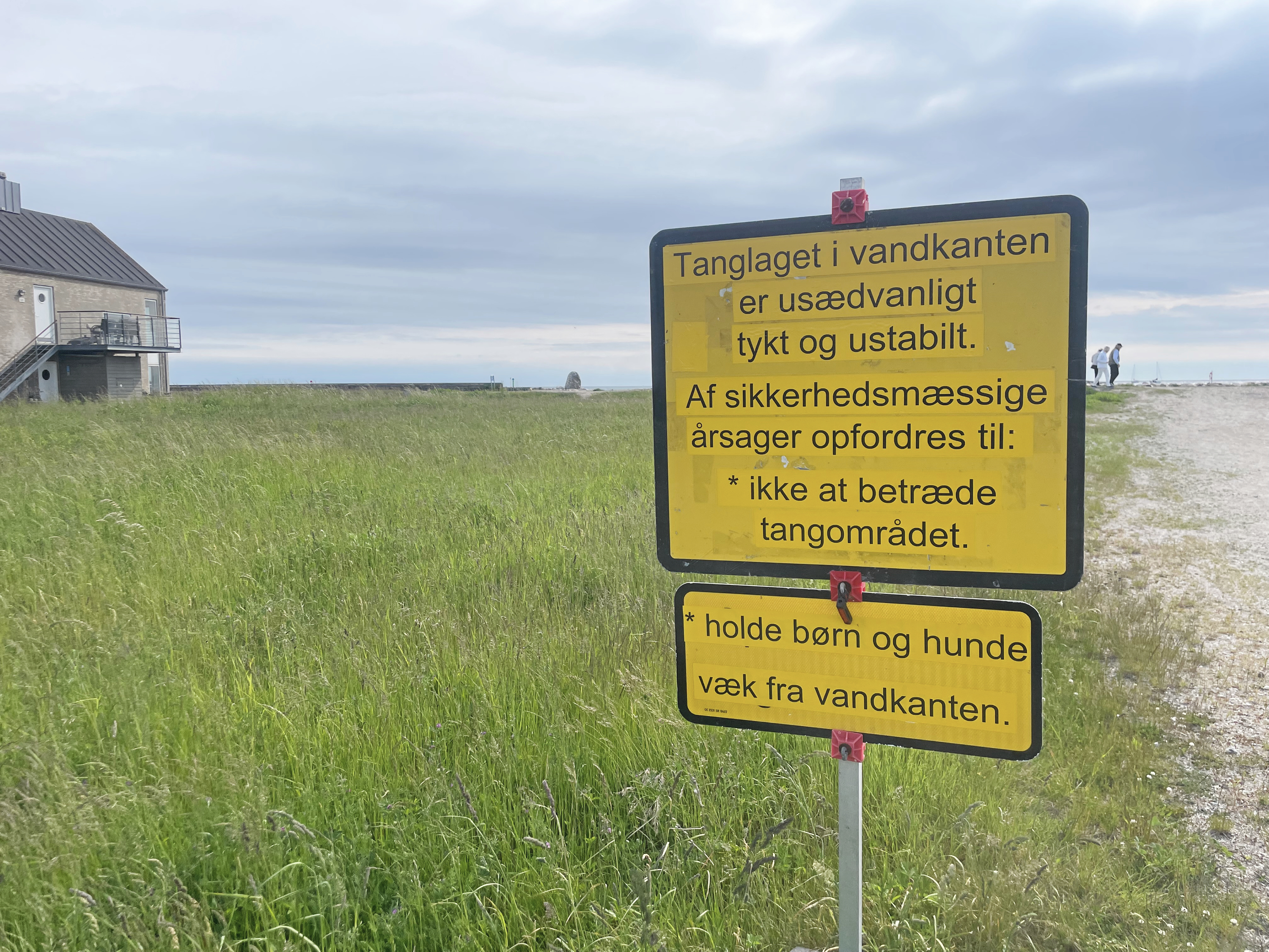 Børn og hunde skal holdes væk fra vandkanten, fremgår det af det gule advarselsskilt.