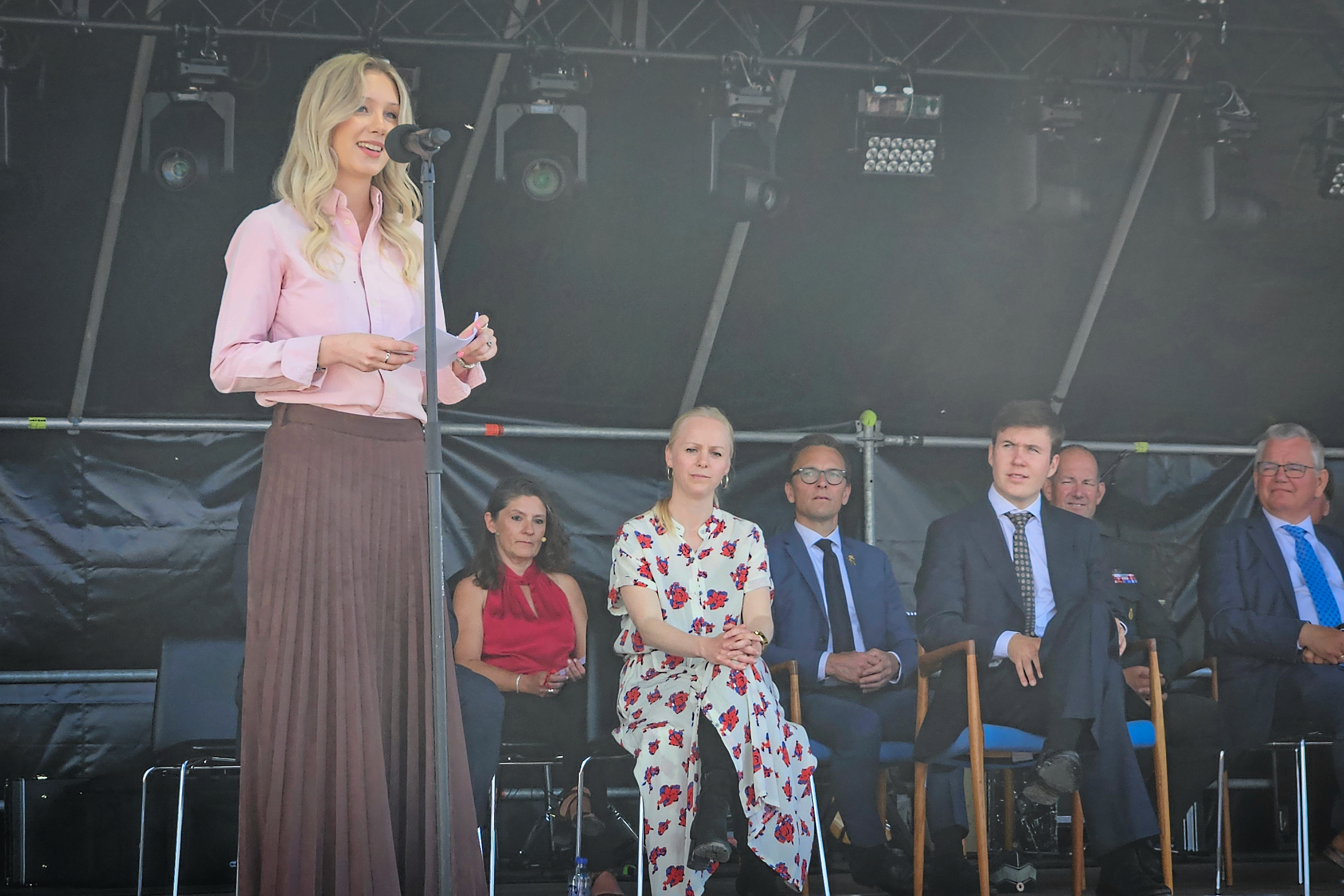 Marie-Elisabeth Christensen var der, da der blev taget det første spadestik, og hun var også med, da den nye bro omsider blev indviet. Her holder hun tale, men både minister, kronprins, direktør og ambasadør lytter med.