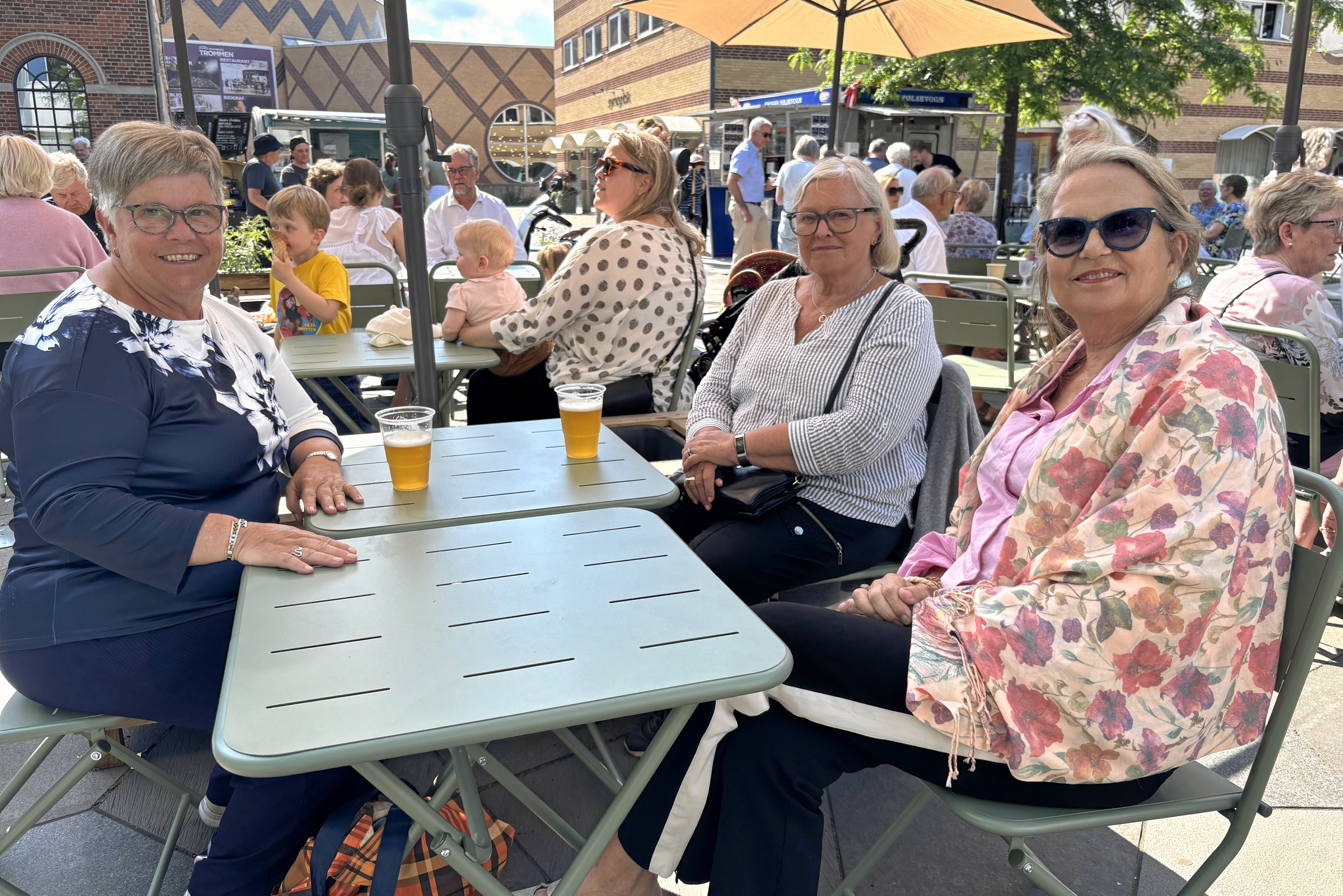 Lene Jakobsen, Vita Berg og Johanne Sjørslev nyder en kold øl i sommervarmen på torvet i bymidten og glæder sig over, at man nu kan mødes og snakke.