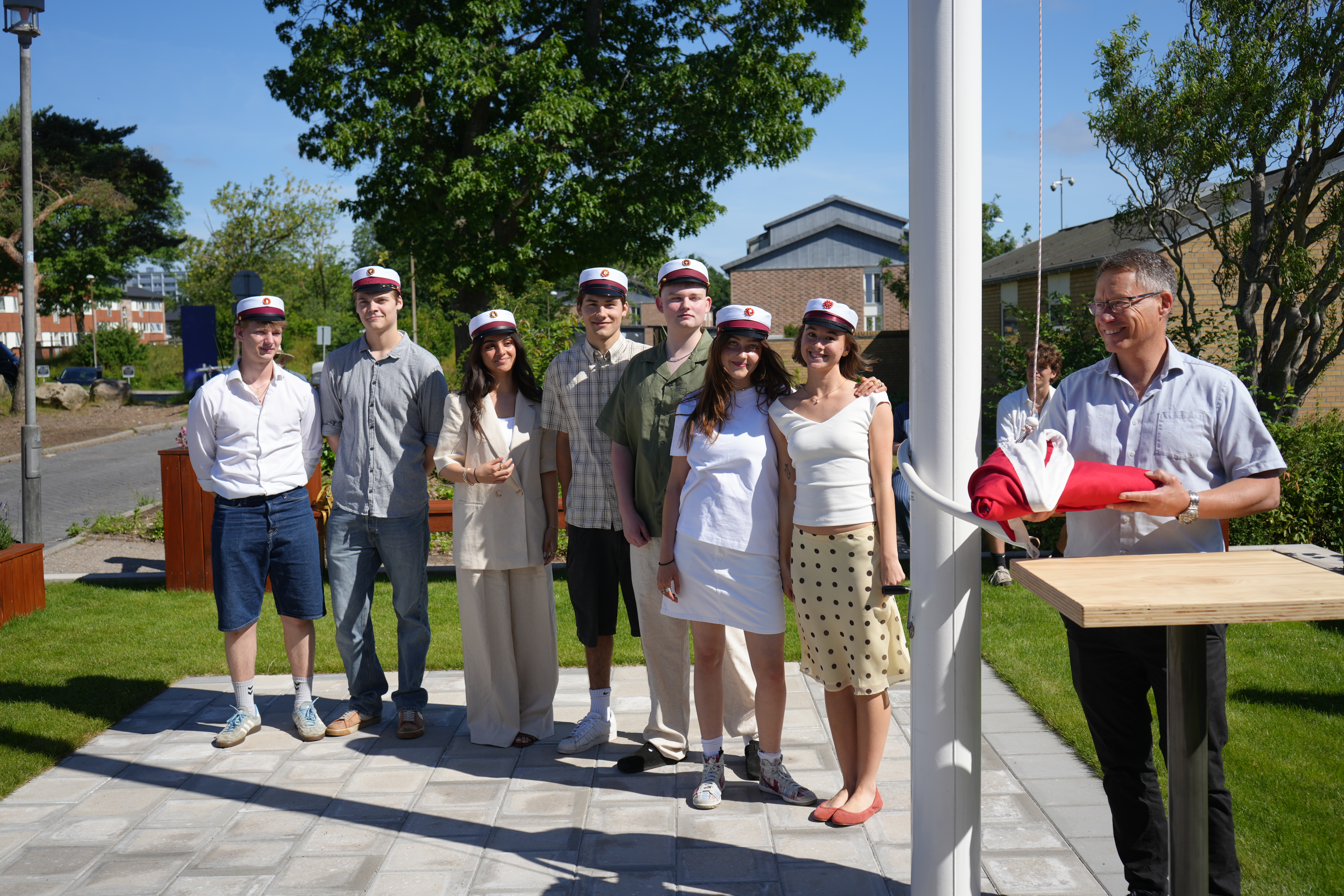 Traditionen tro hejser de første studenter flaget med rektor. Her ses studenterne Laura Hoffmann (3.x), Carla Højstrøm (3.z), Vilfred Heller (3.v), Oskar Kofod Rosendal (3.v), Nisa Nur Celik (3.t), Laurits Wagner Njød (3.s), Signe Munch (3.z) og Gabriel Knørr El Raheb (3.c).