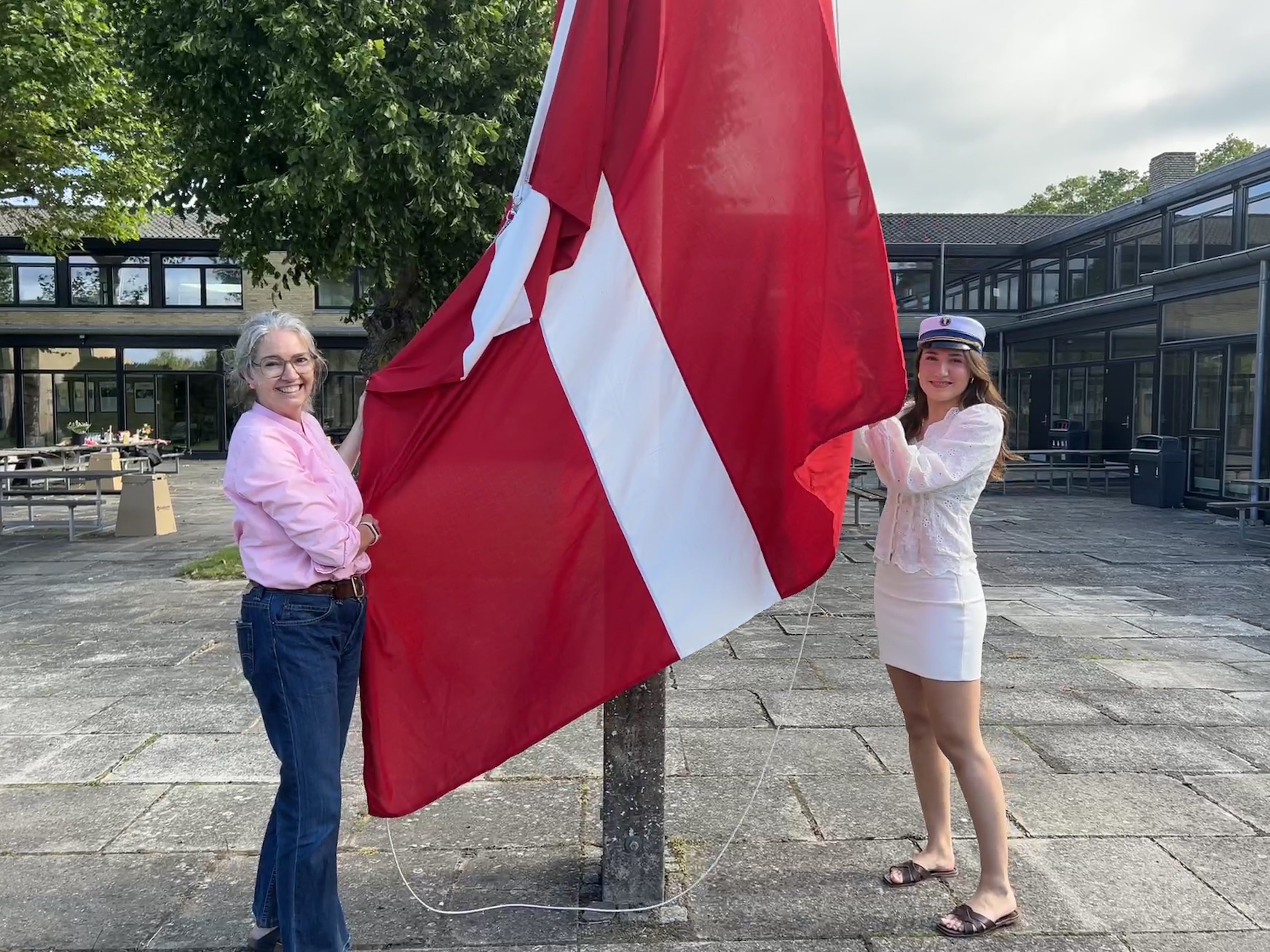 Emma Billen (th.) var, som en af skolens første studenter i år, med til at hejse flaget.