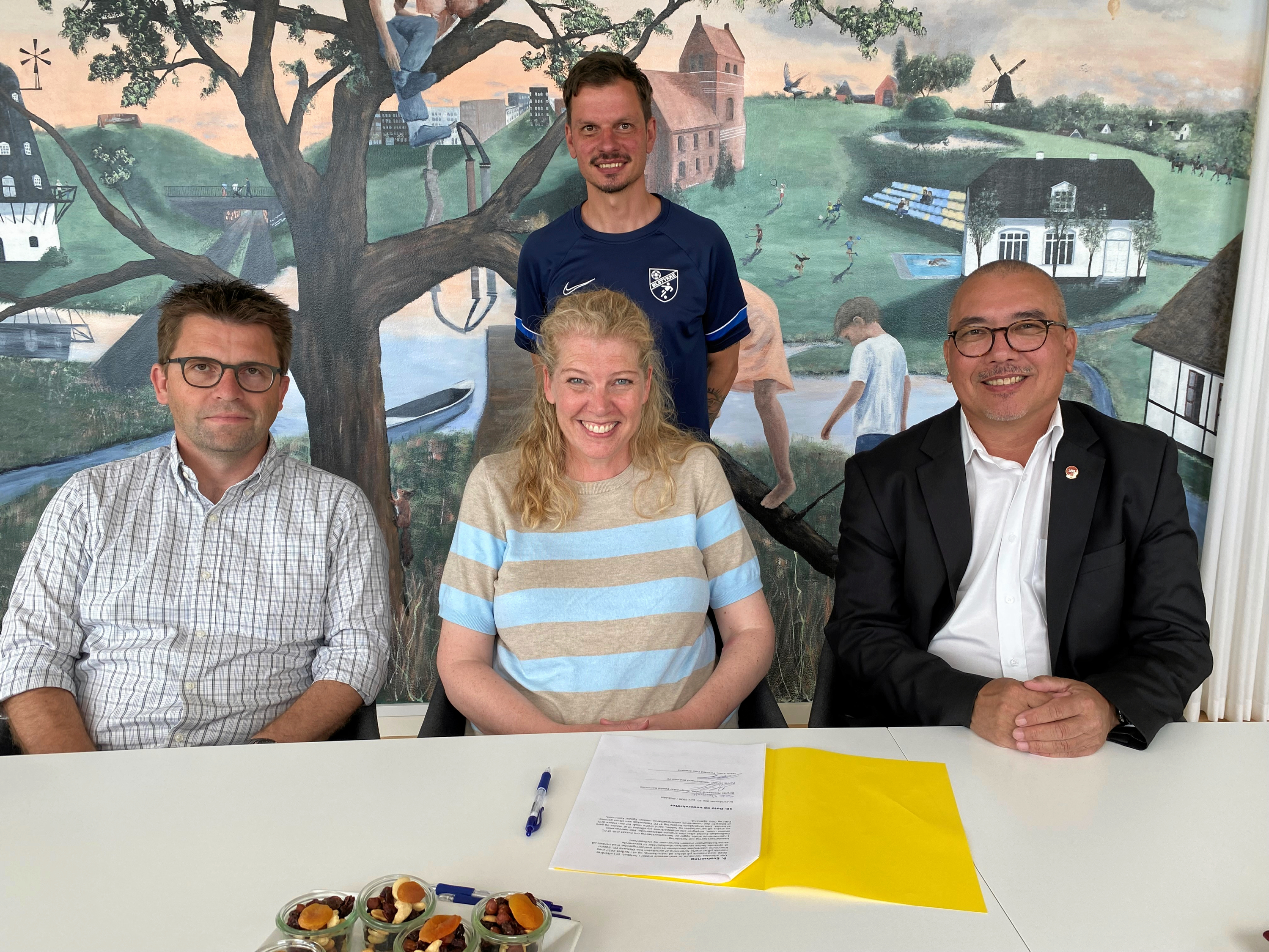 Underskrifterne på aftalen blev sat af næstformand i Ølstykke FC Henrik Jensen, borgmester Birgitte Neergaard-Kofod og formand i DBU Sjælland, Jakob Koed, mens daglig leder i Ølstykke FC og træner på FC Fællesskab Mads Peder Thomsen fulgte med.