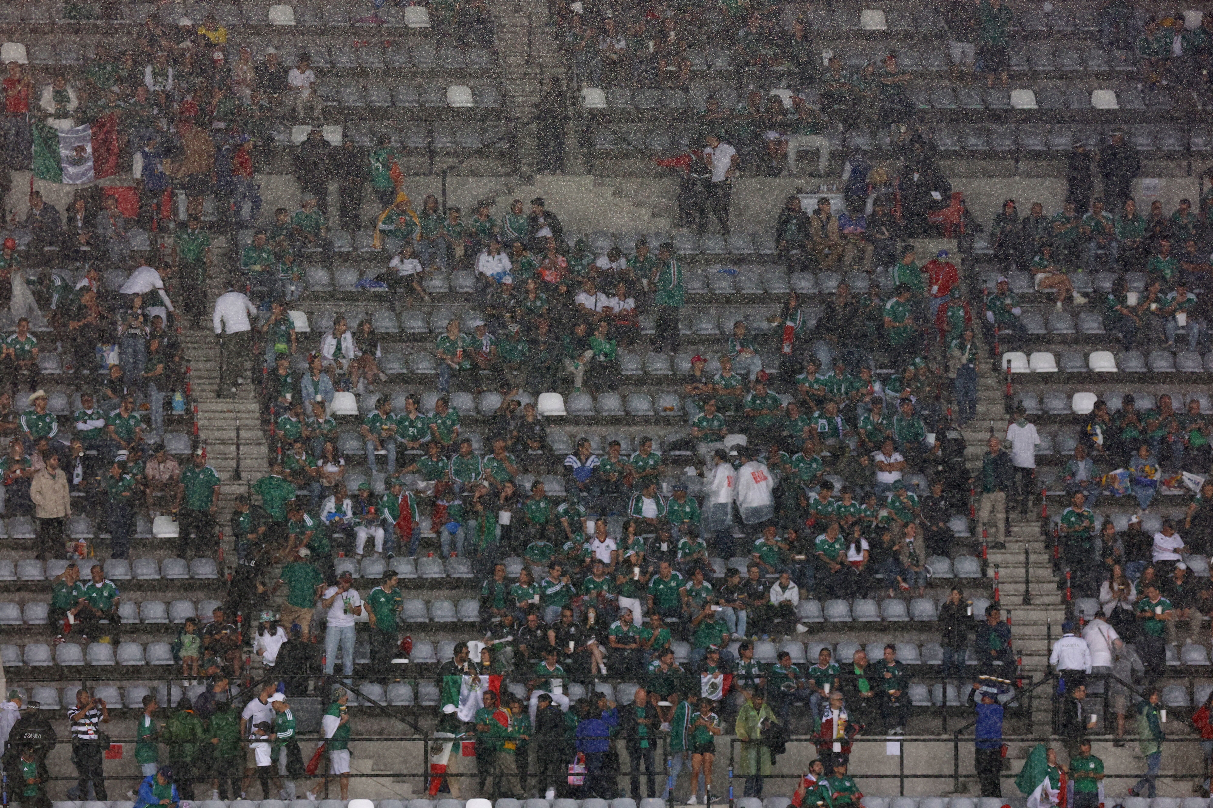 Regnen siler ned over mexicanske tilskuere på Estadio Azteca.