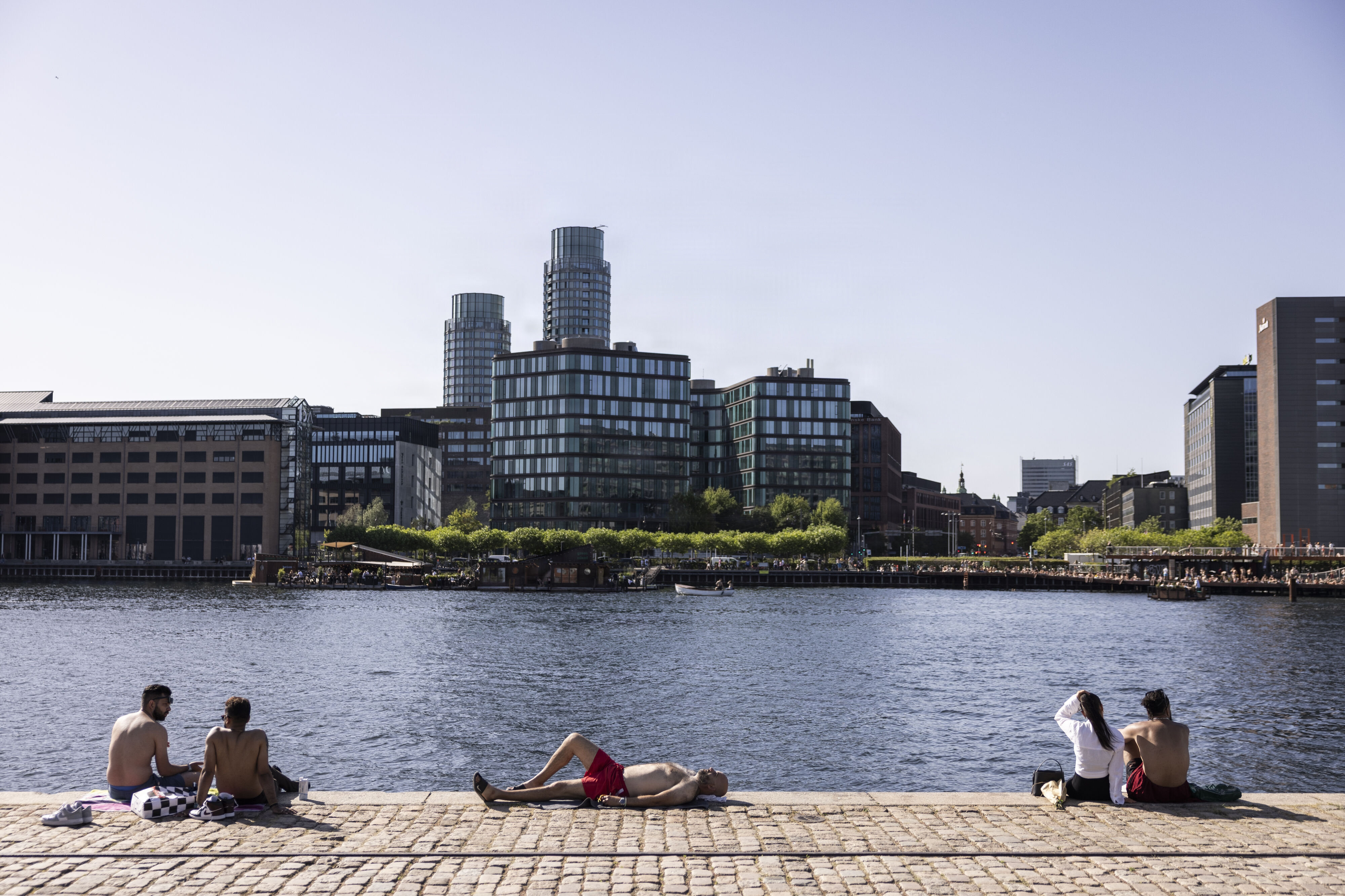 Muligheden for at hoppe i Københavns havn nævnes som en af grundene til, at den danske hovedstad er blandt de bedste byer at leve i. På billedet ses folk på havnefronten på Islands Brygge. (Arkivfoto).