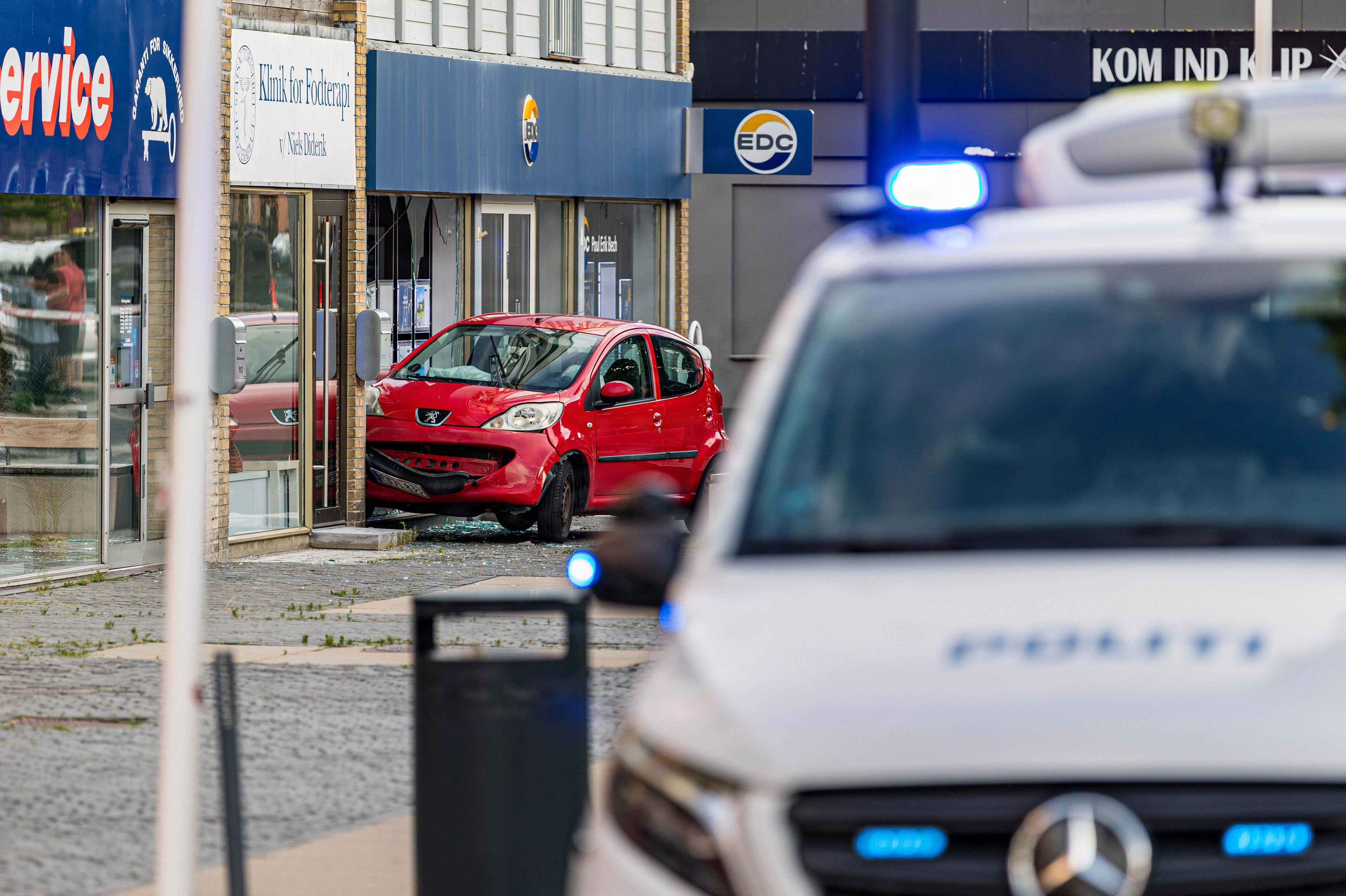 En bil kan være endt i butiksfacade, fordi en gruppe unge mænd forsøgte at påkøre en anden gruppe fredag aften på hovedgaden i Taastrup.