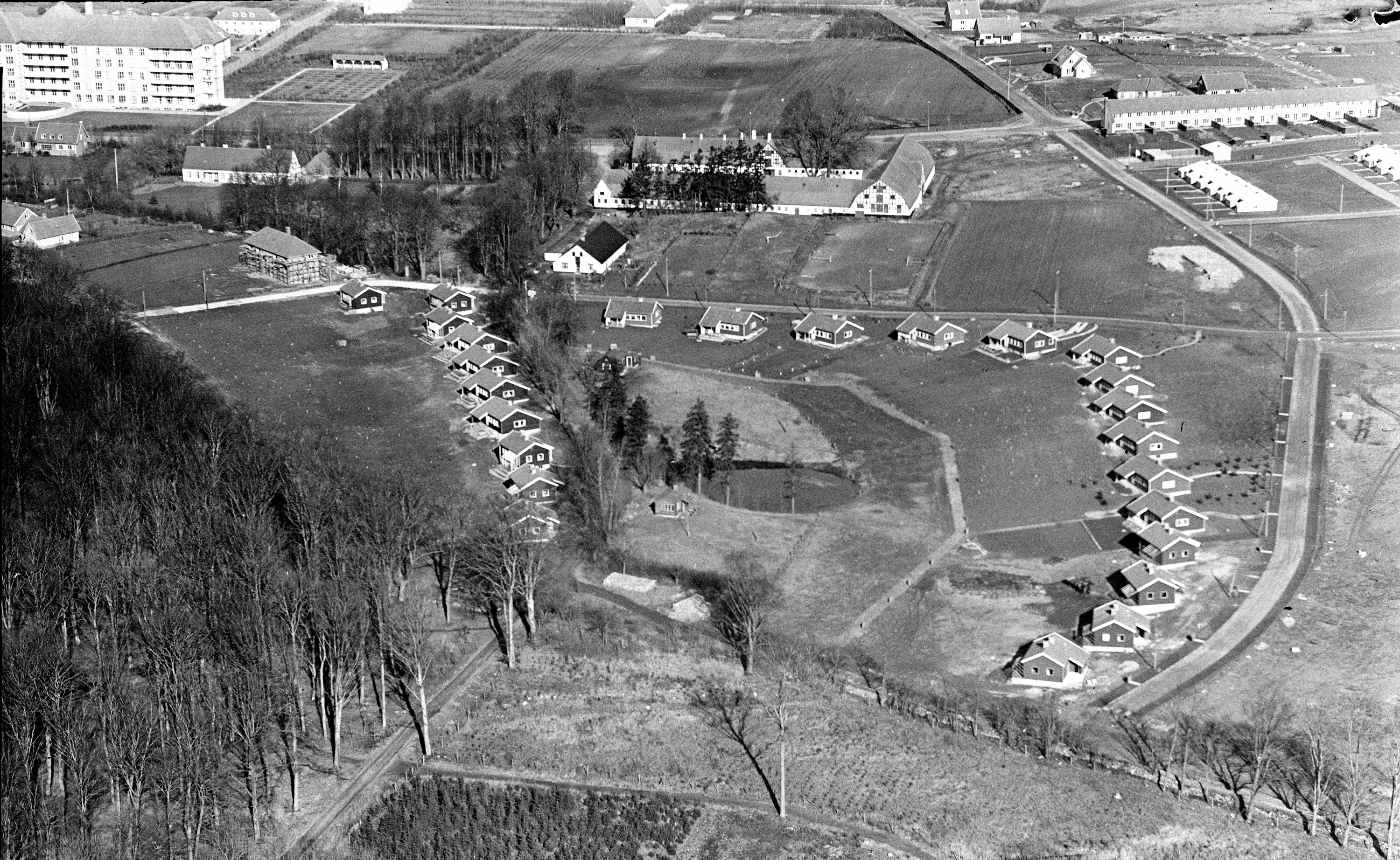 Sylvest Jensens luftfoto fra 1956 giver et godt indtryk af området. I bunden ses Finn-husene, og på sydsiden af gavlen på Sandviggård ses den lille fodboldbane. I toppen ses Dyrehavevej og en del af det sygehus, der blev bygget under Anden Verdenskrig. Foto tilhører - Det Kgl. Bibliotek/Sylvest Jensen Sylvest Jensens luftfoto fra 1956 giver et godt indtryk af området. I bunden ses Finn-husene, og på sydsiden af gavlen på Sandviggård ses den lille fodboldbane. I toppen ses Dyrehavevej og en del af det sygehus, der blev bygget under Anden Verdenskrig. Foto tilhører