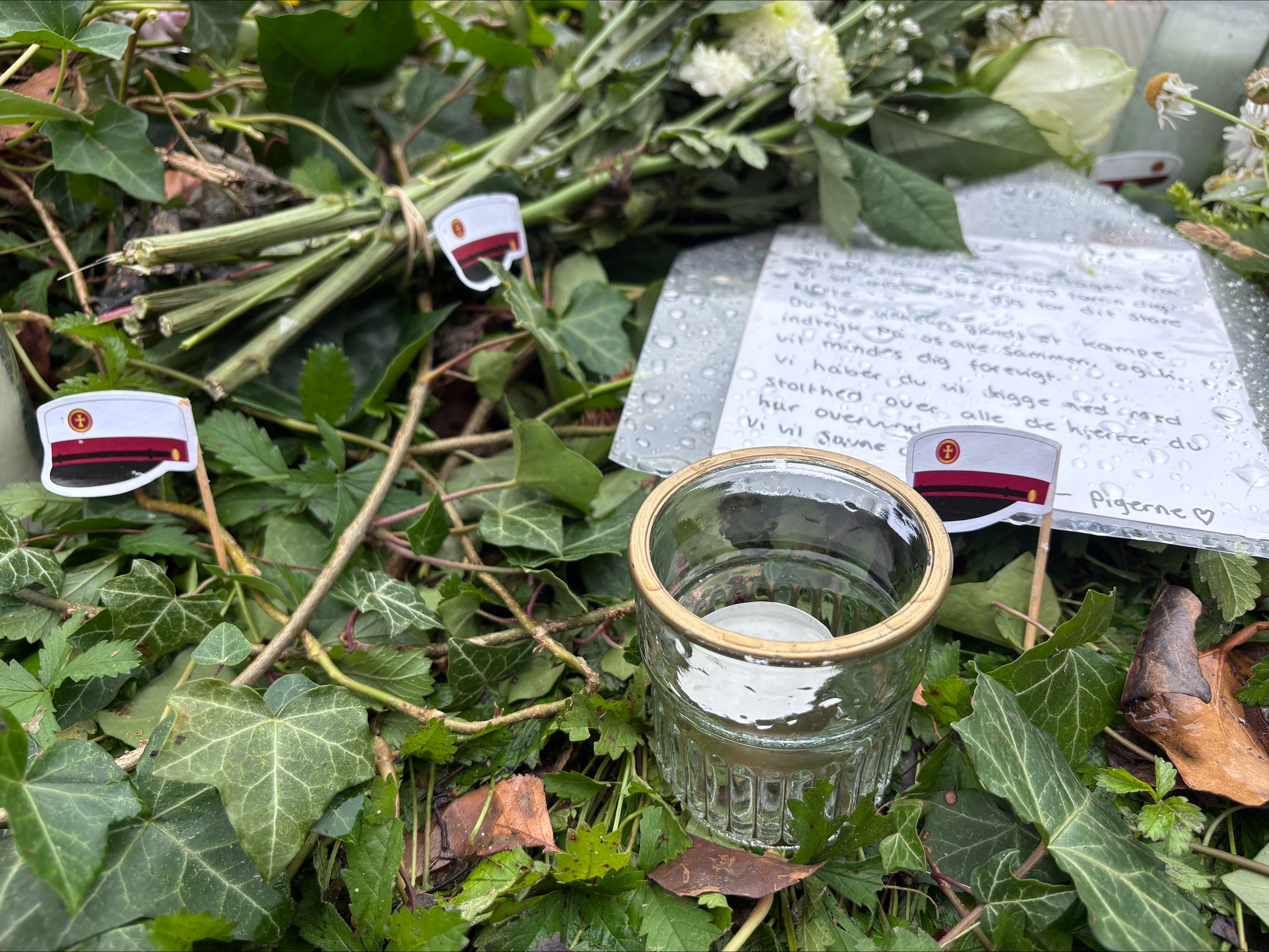 Blomster, lys og hilsner er lagt ved ulykkesstedet, hvor en 20-årig mand fra lokalområdet mistede livet natten til søndag.