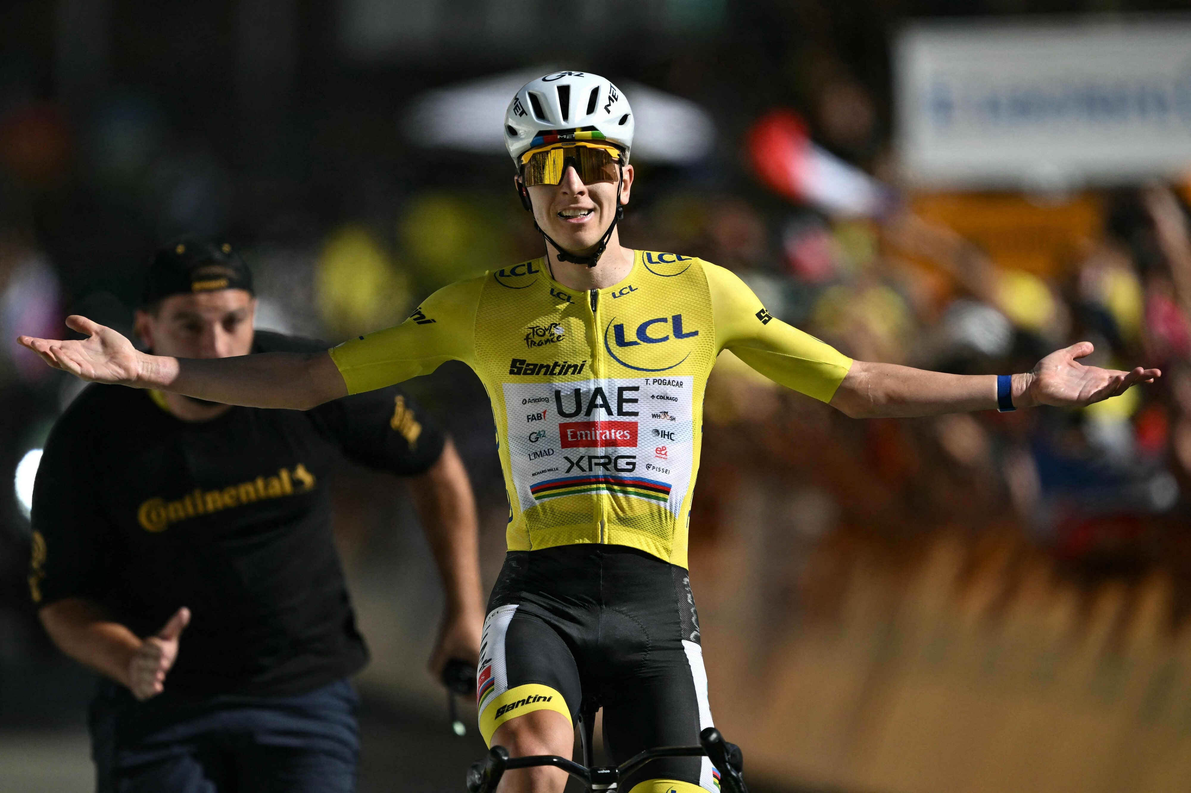 Tadej Pogacar kører jublende over målstregen på L'Alpe d'Huez.
