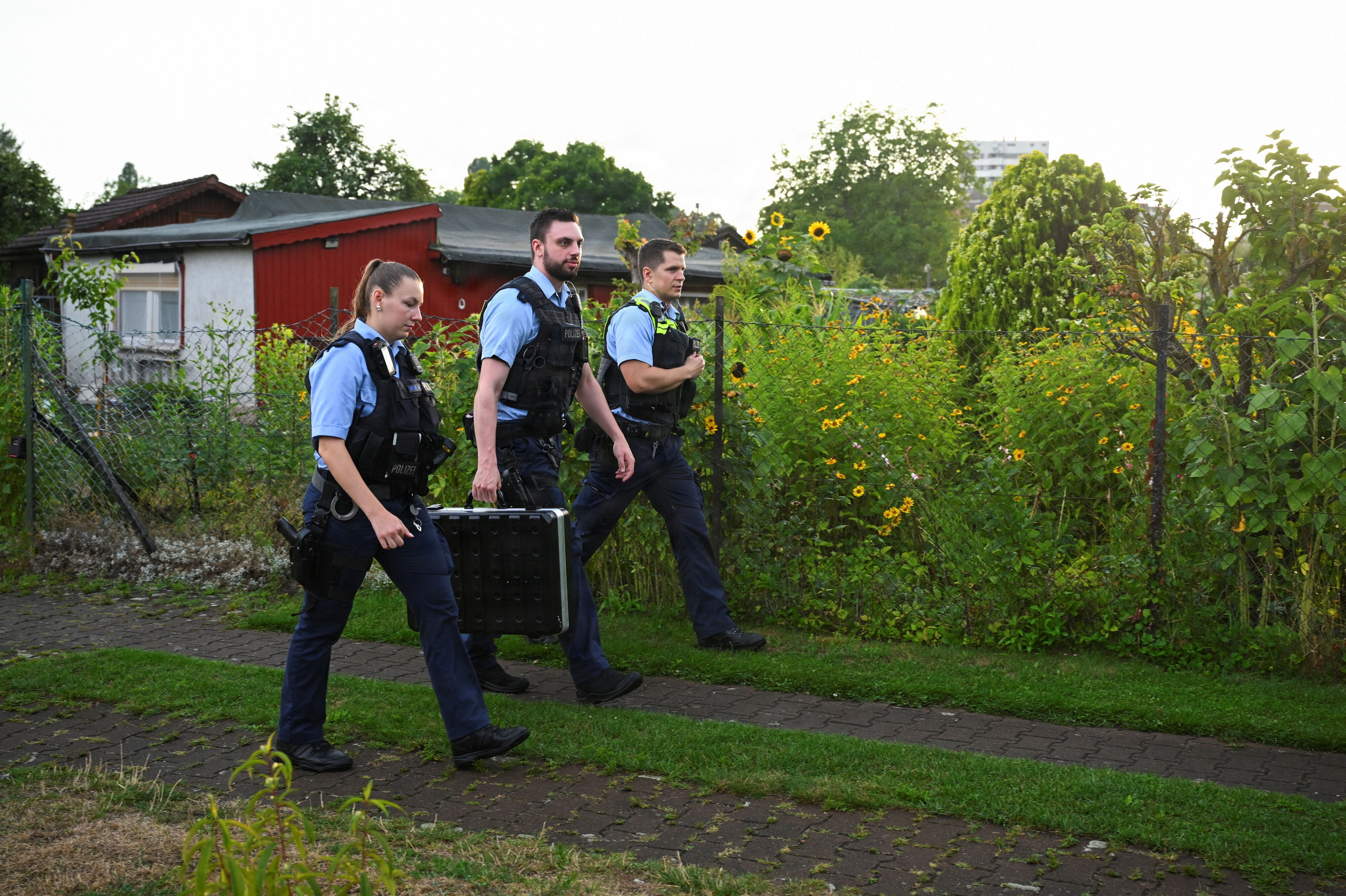 Politiet arbejder i det kolonihaveområde i Spandau i udkanten af Berlin, hvor den 21-årige mistænkte blev fundet og skudt søndag ved 18-tiden.