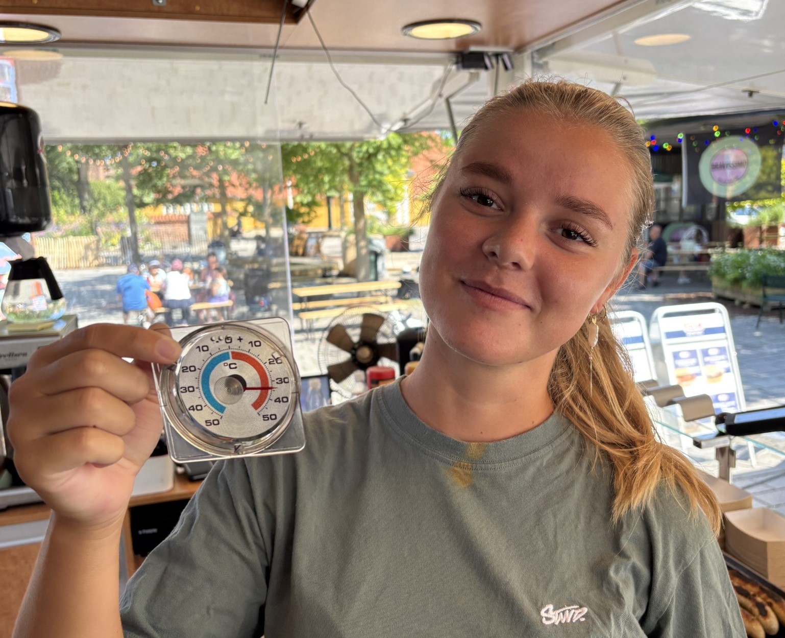 Freja Valentin Hansen vender pølser og bugerbøffer i 33 graders varme.