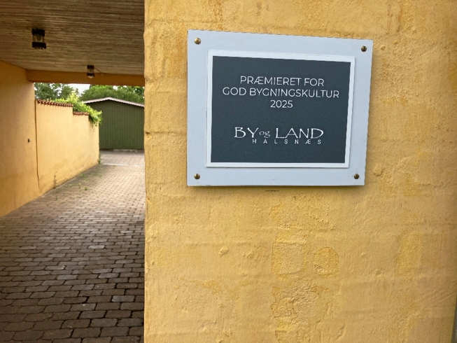Vinderen får ikke en kæmpe præmie. Ud over æren får man diplom og plakette med By & Lands logo til at sætte op på facaden. - By og Land Halsnæs Vinderen får ikke en kæmpe præmie. Ud over æren får man diplom og plakette med By & Lands logo til at sætte op på facaden.