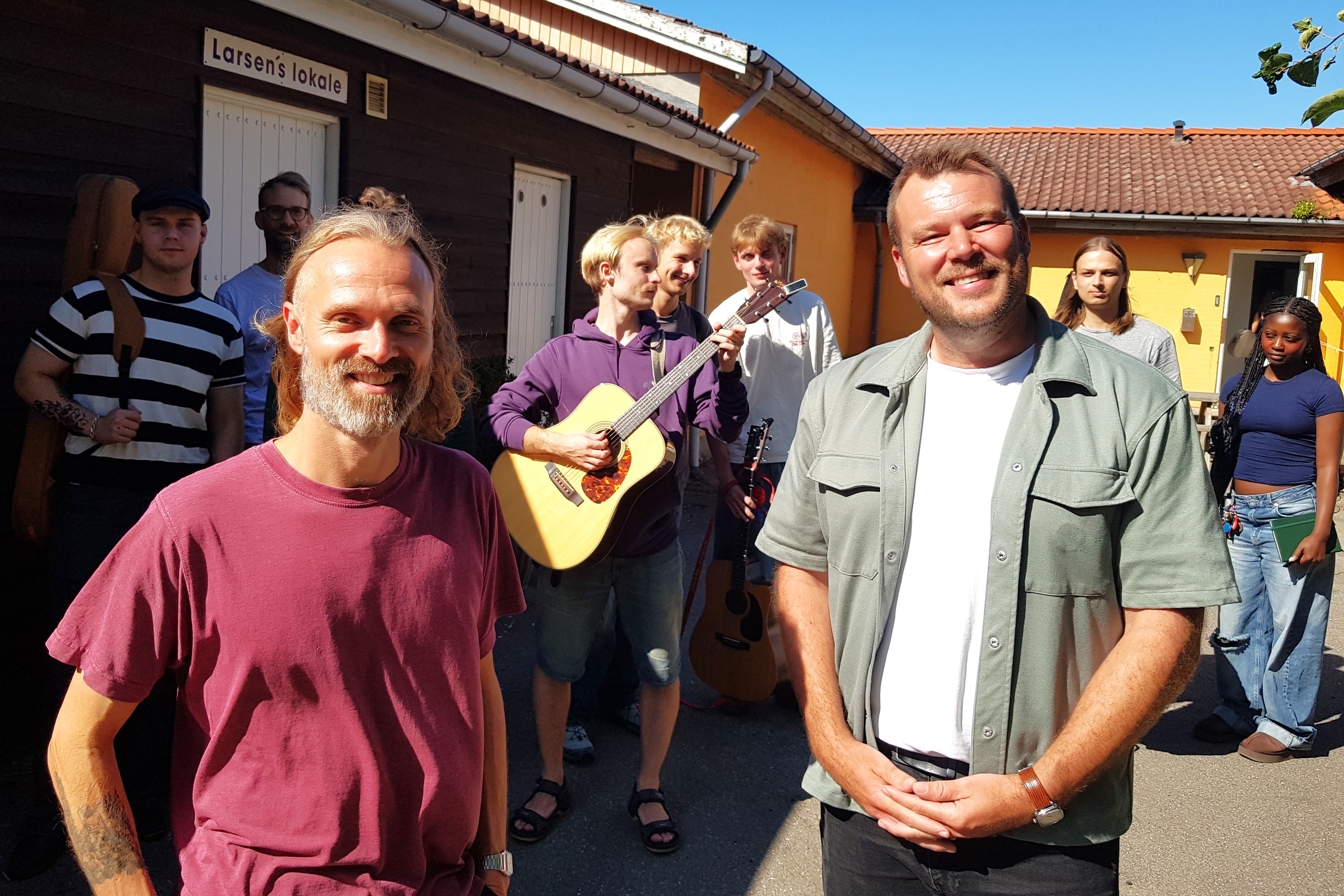 Viceforstander Kristian Næsby (th.) og projektmedarbejder Mads Bendes sammen med elever på Den Rytmiske Højskole, der nu præsenteres for Rytmisk Medborgerskab.