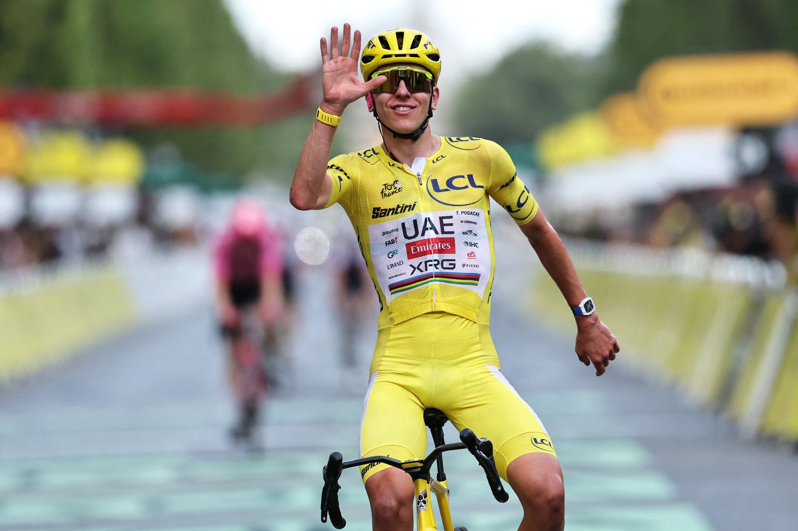 Tadej Pogacar fremviser fem fingre for at vise, at han har vundet Tour de France fem gange. Lørdag er sloveneren med i feltet, når Vuelta a Espana skydes i gang i Monaco. (Arkivfoto).