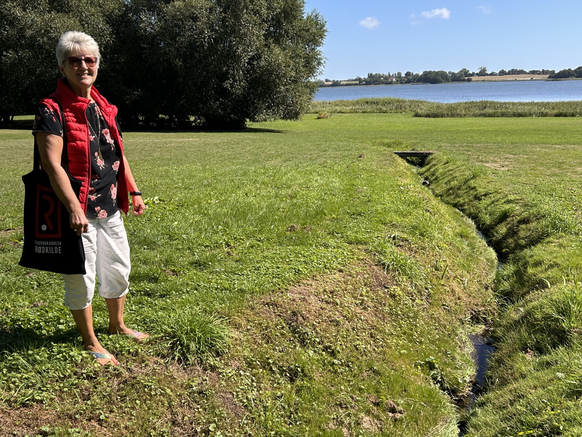 Bente Ravn ved den lille del af kilden, man stadig kan se i dag. Størstedelen er med tiden blevet rørtført under jorden.