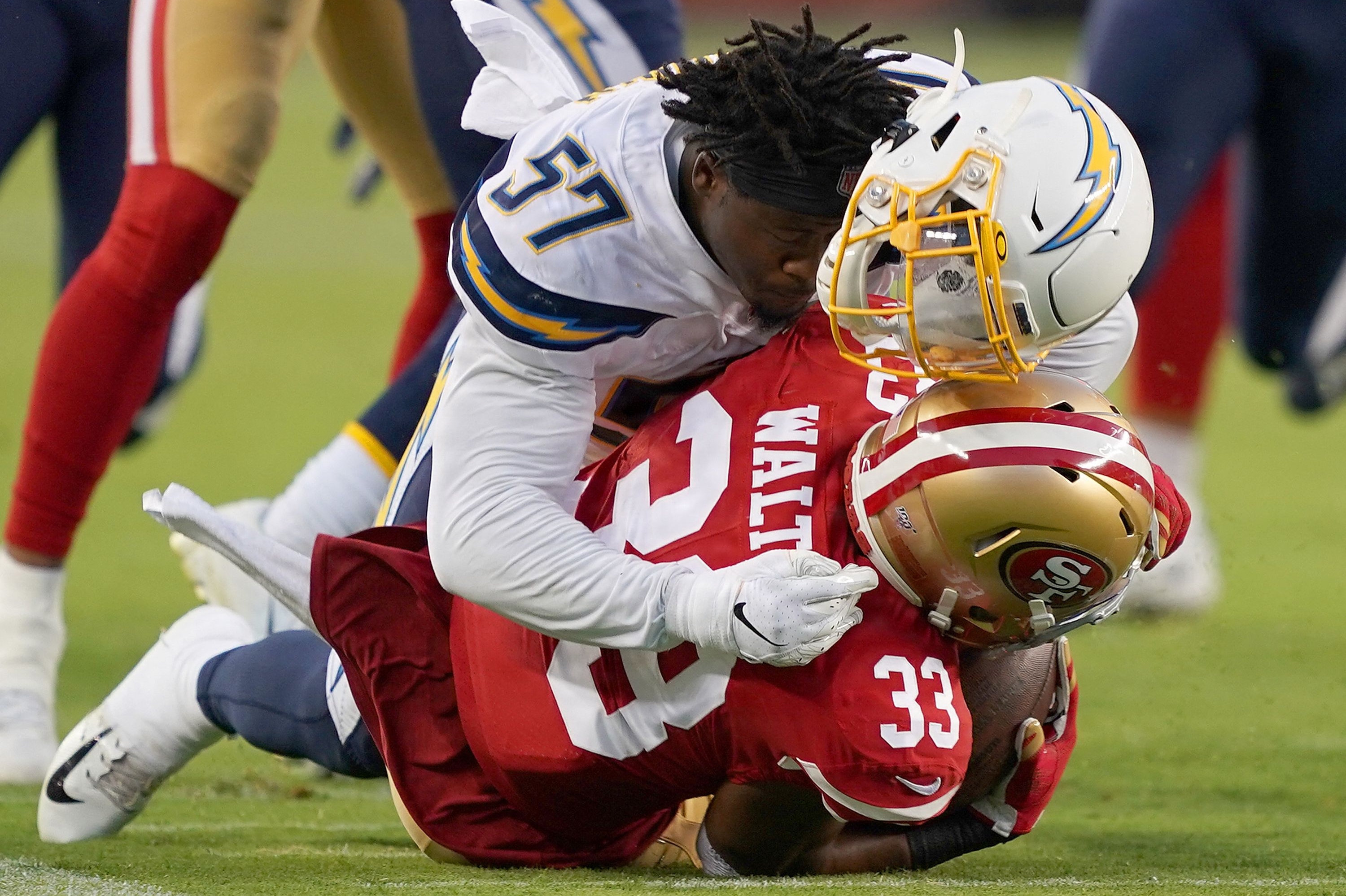 En NFL-spiller taber sin hjelm under en hård tackling. Gentagne slag mod hovedet kan medføre hjernesygdommen CTE. Forskere har undersøgt en række afdøde NFL-spilleres hjerner for sygdommen. (Arkivfoto).