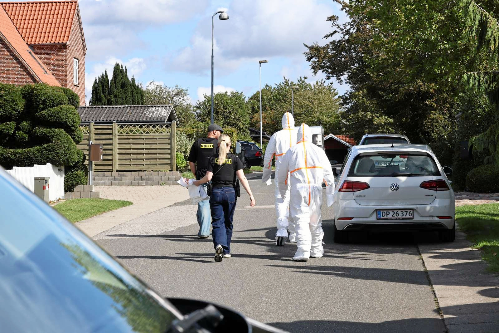 Billeder fra Kalundborg viser, at to personer i dna-dragter tirsdag er blevet ført væk af politiet.
