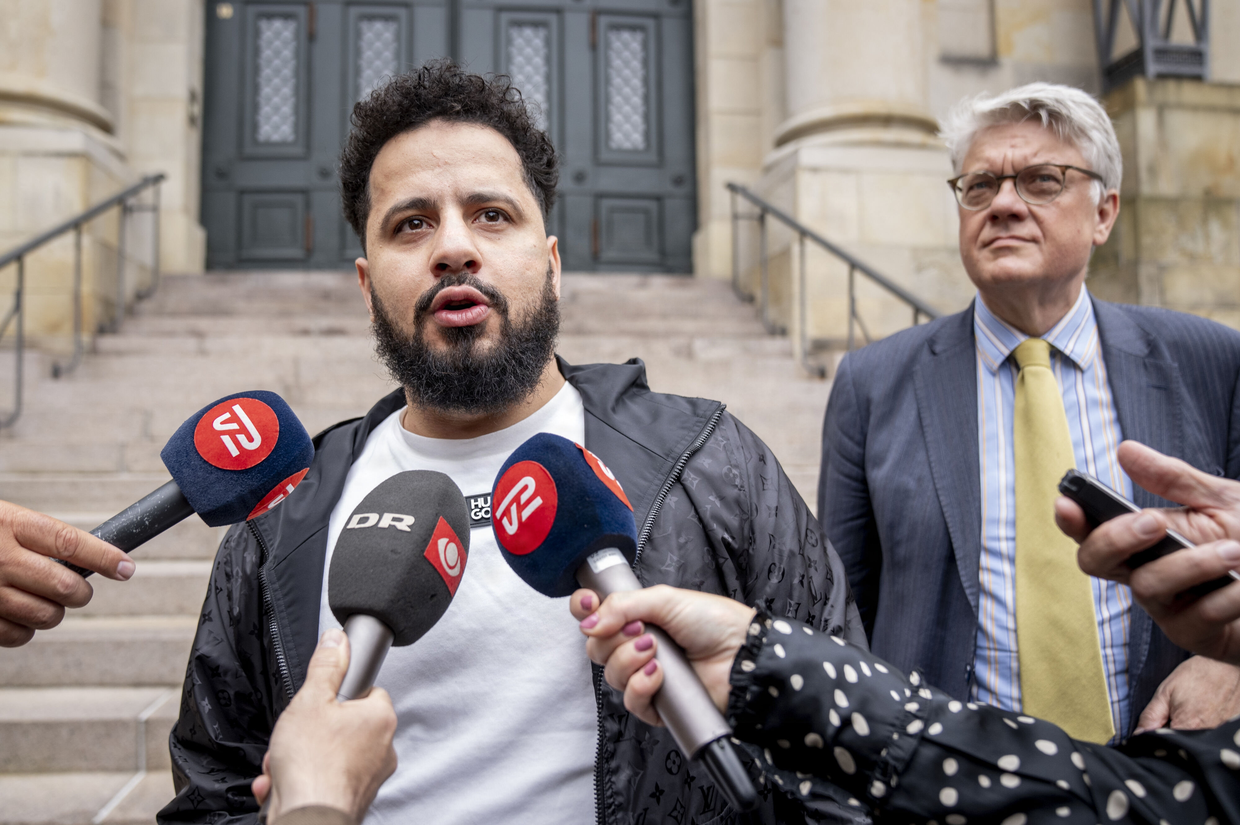 Ahmed Samsam har onsdag bedt om at få sin straffesag i Spanien genoptaget. Her ses Ahmed Samsam (forrest) med sin danske forsvarsadvokat, René Offersen, efter at Højesteret afsagde dom i hans sag sidste år. (Arkivfoto).
