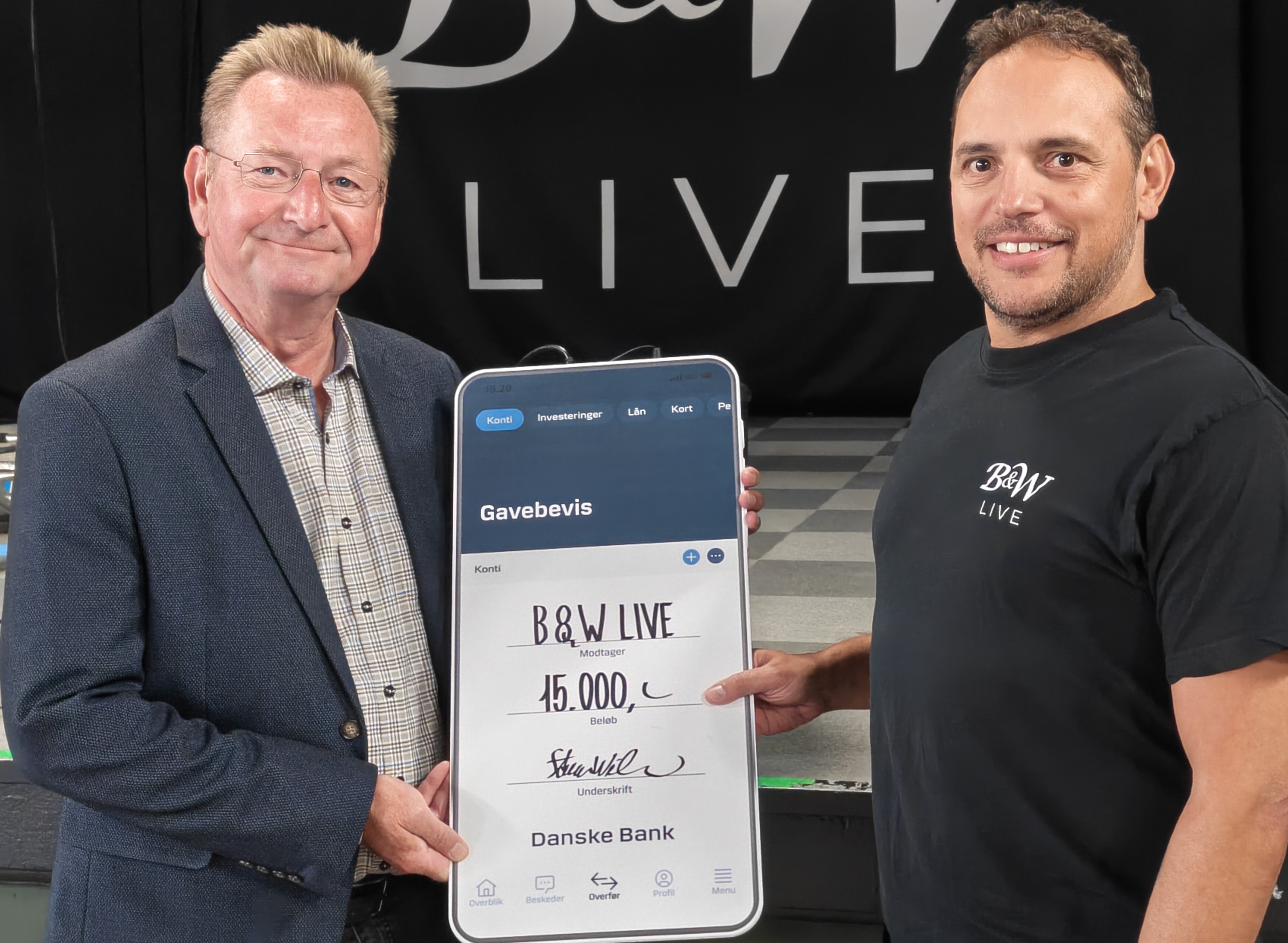Steen Wisler fra Danske Bank Haslev Fonden overrækker en check til bestyrelsesmedlem i B&W Live, Henrik Holmgaard.